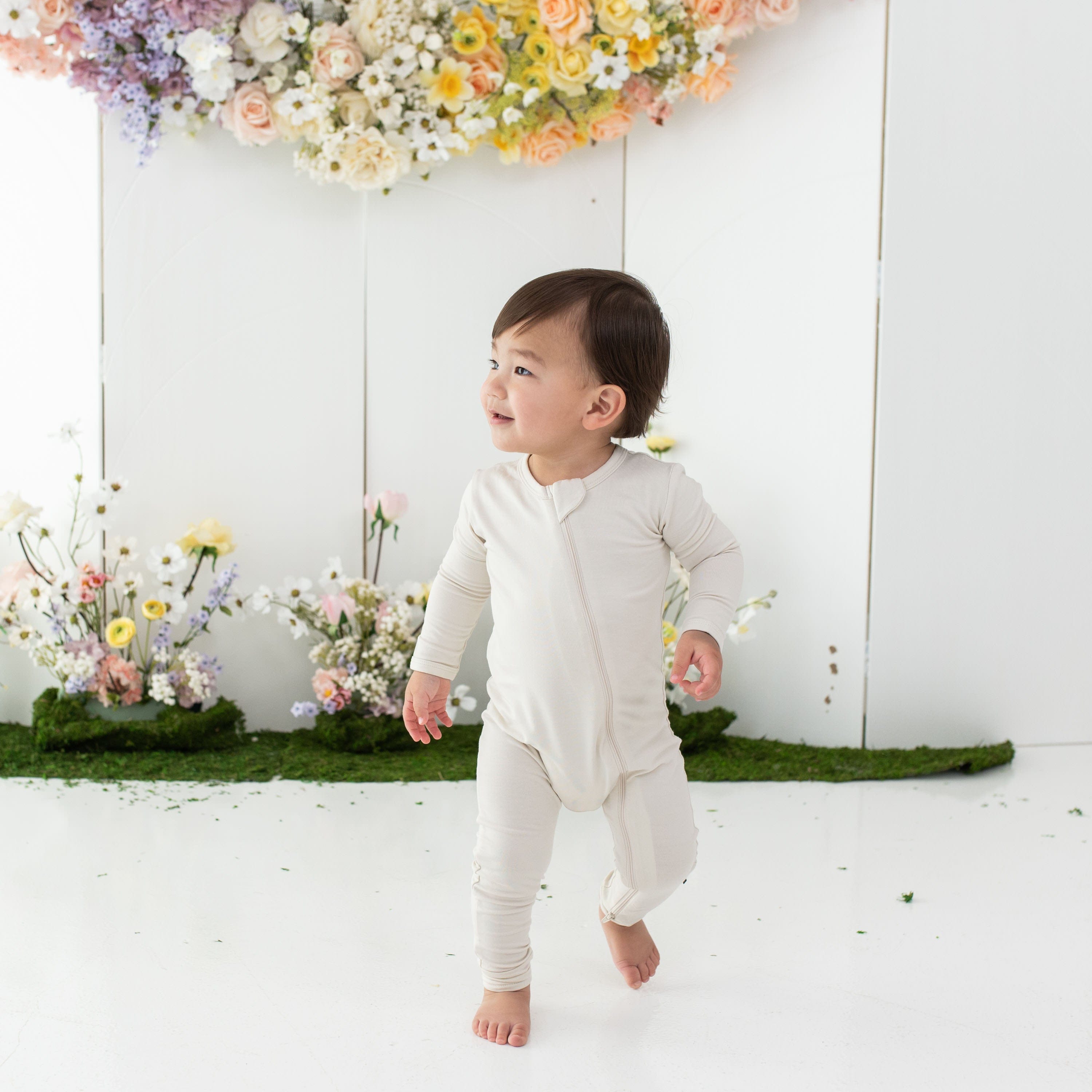 Toddler wearing Kyte Baby Zippered Romper in Ecru