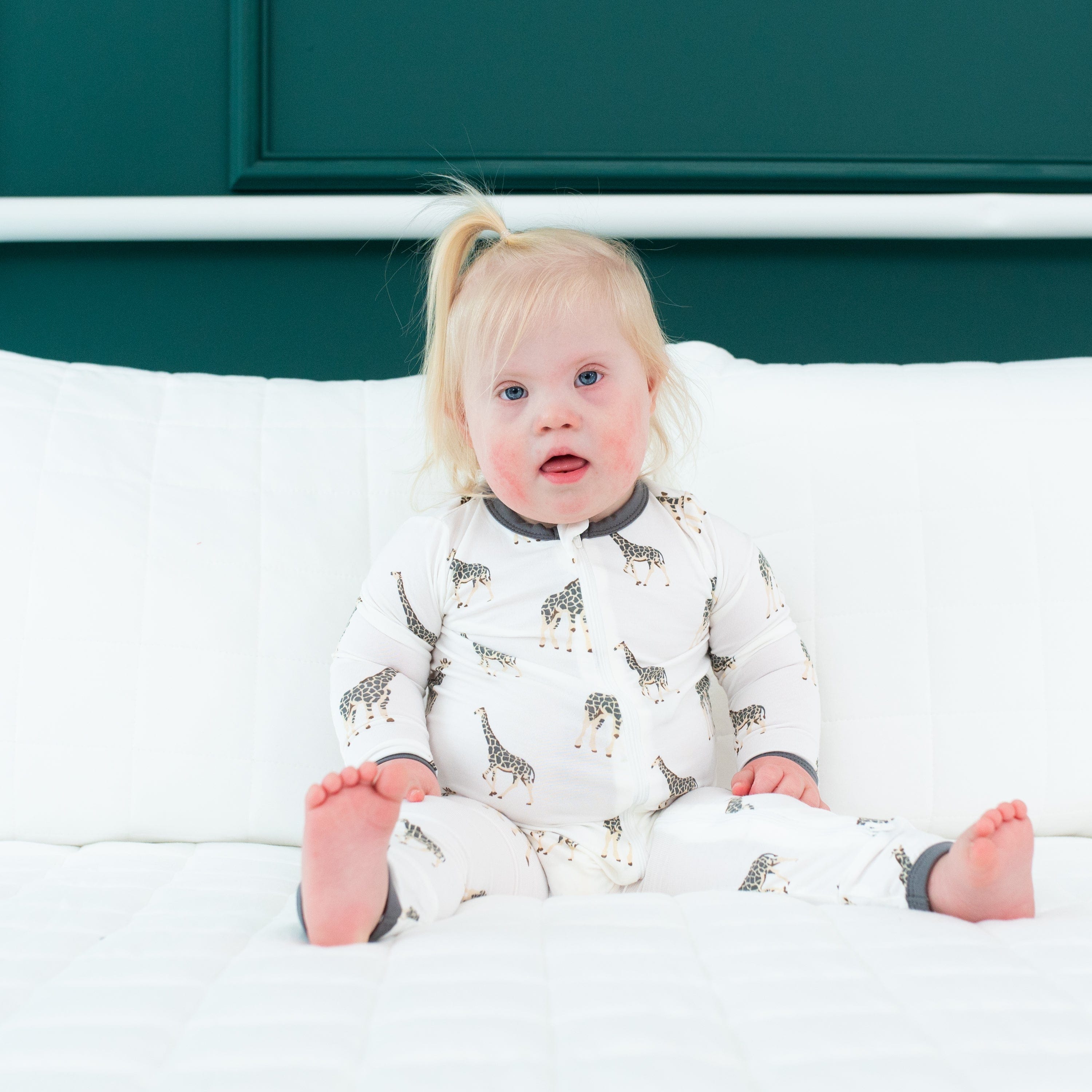 Girl wearing Kyte Baby Zippered Romper in Giraffe