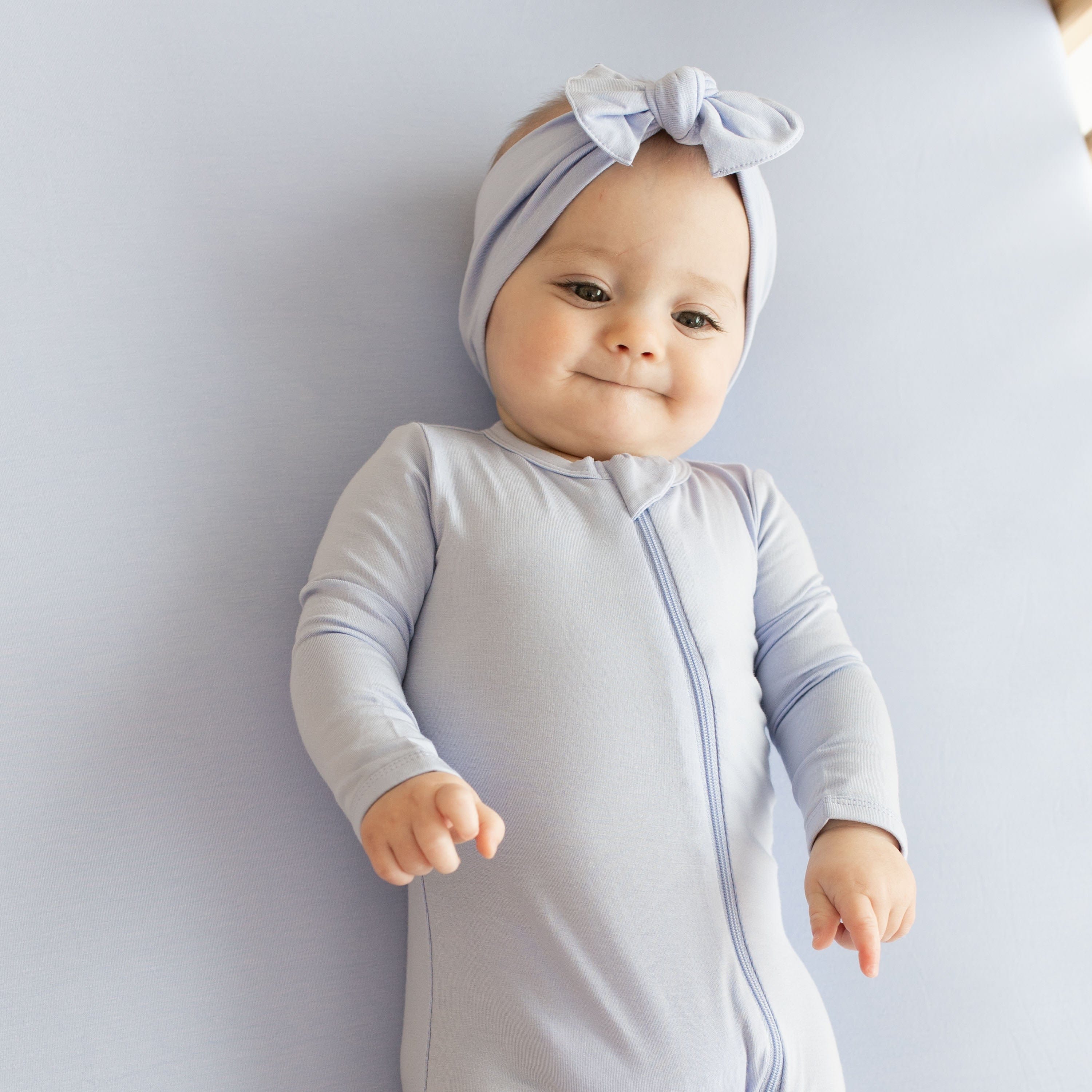 Baby wearing Kyte Baby Zippered Romper in Lilac