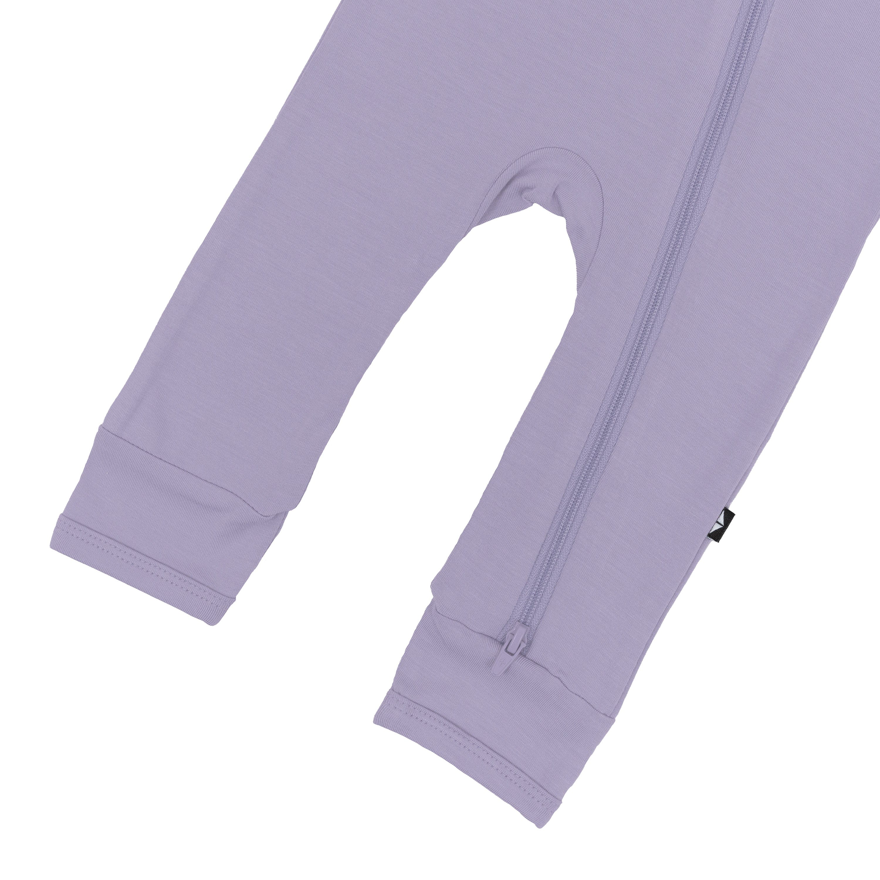 Close up of open feet and bottom zipper on Kyte Baby Zippered Romper in Taro