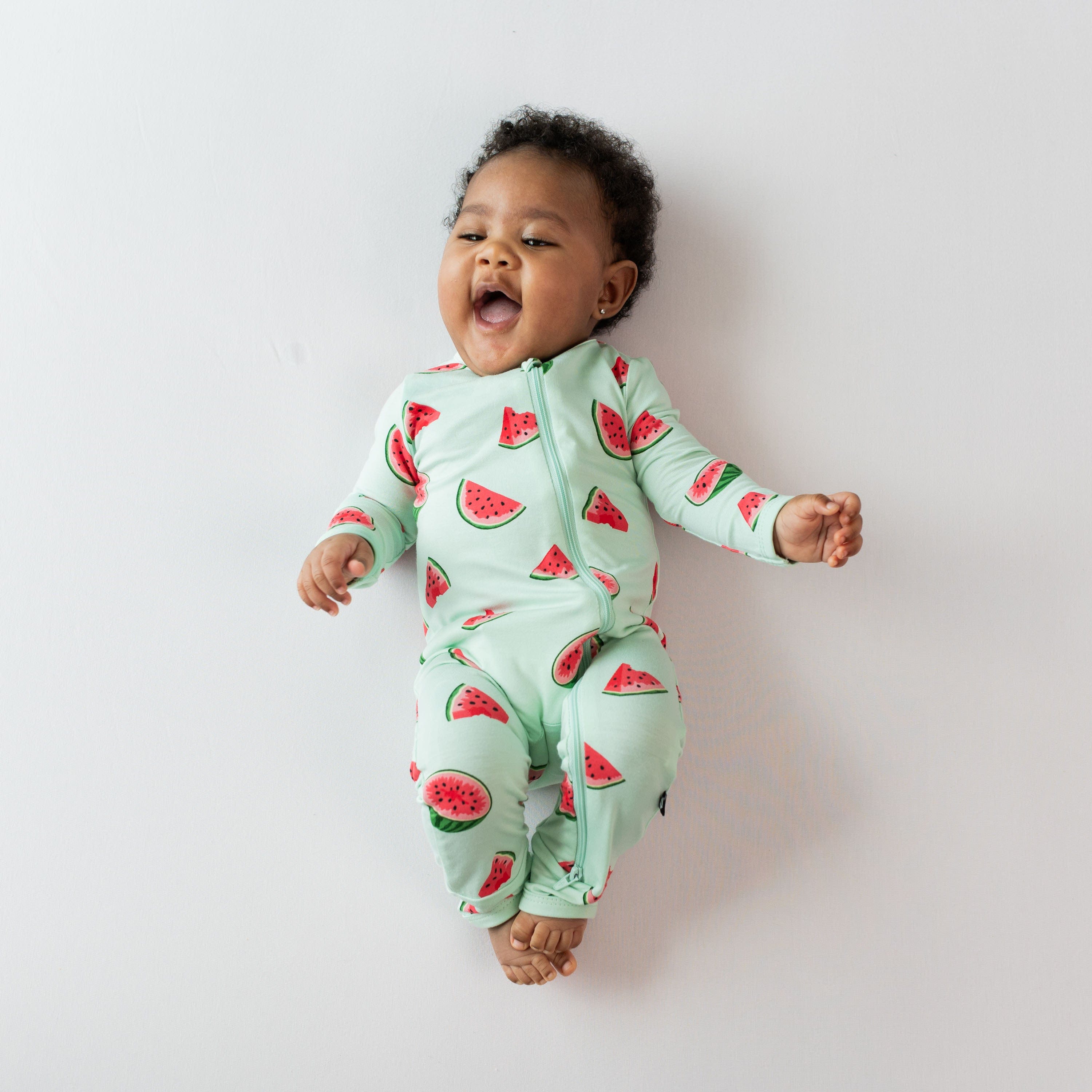Infant wearing Kyte Baby bamboo Zippered Romper in Watermelon pattern