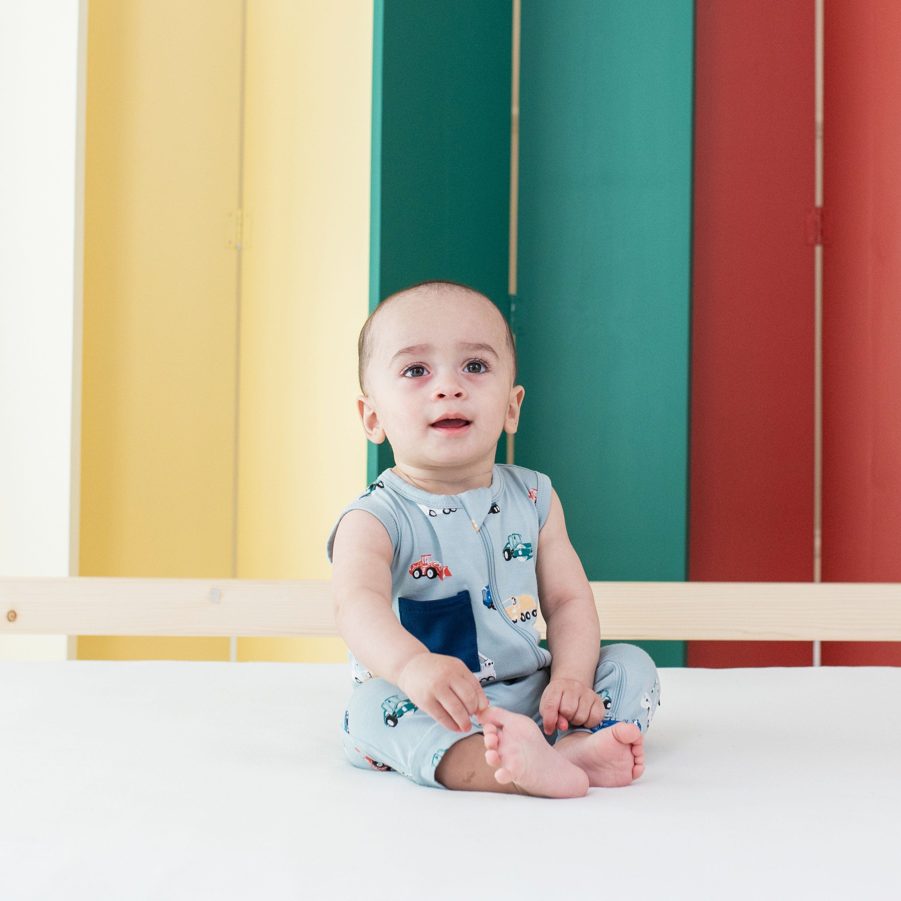 Child wearing Kyte Baby Sleeveless Zippered Romper in Construction