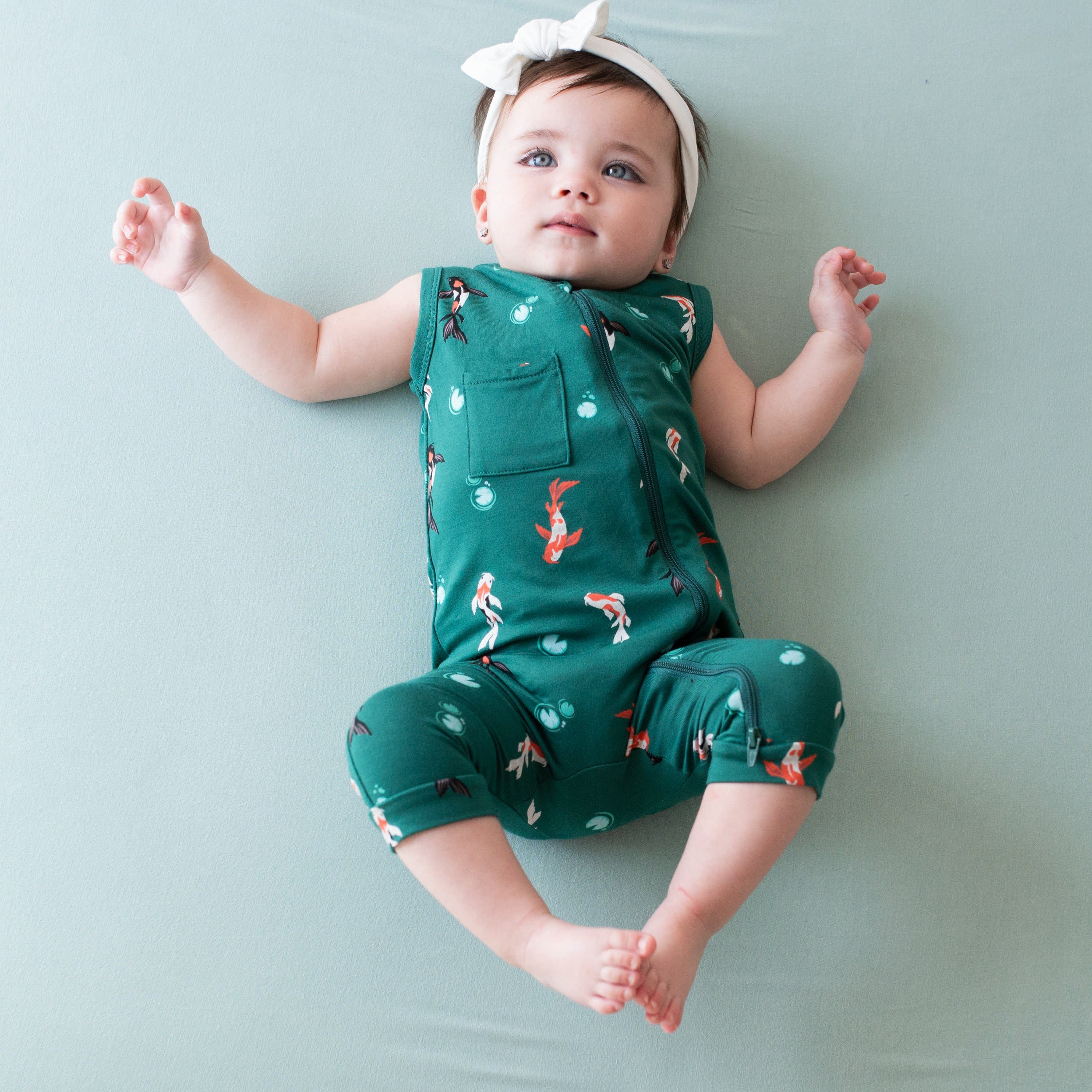 Baby wearing Kyte Baby bamboo Zippered Sleeveless Romper in Koi