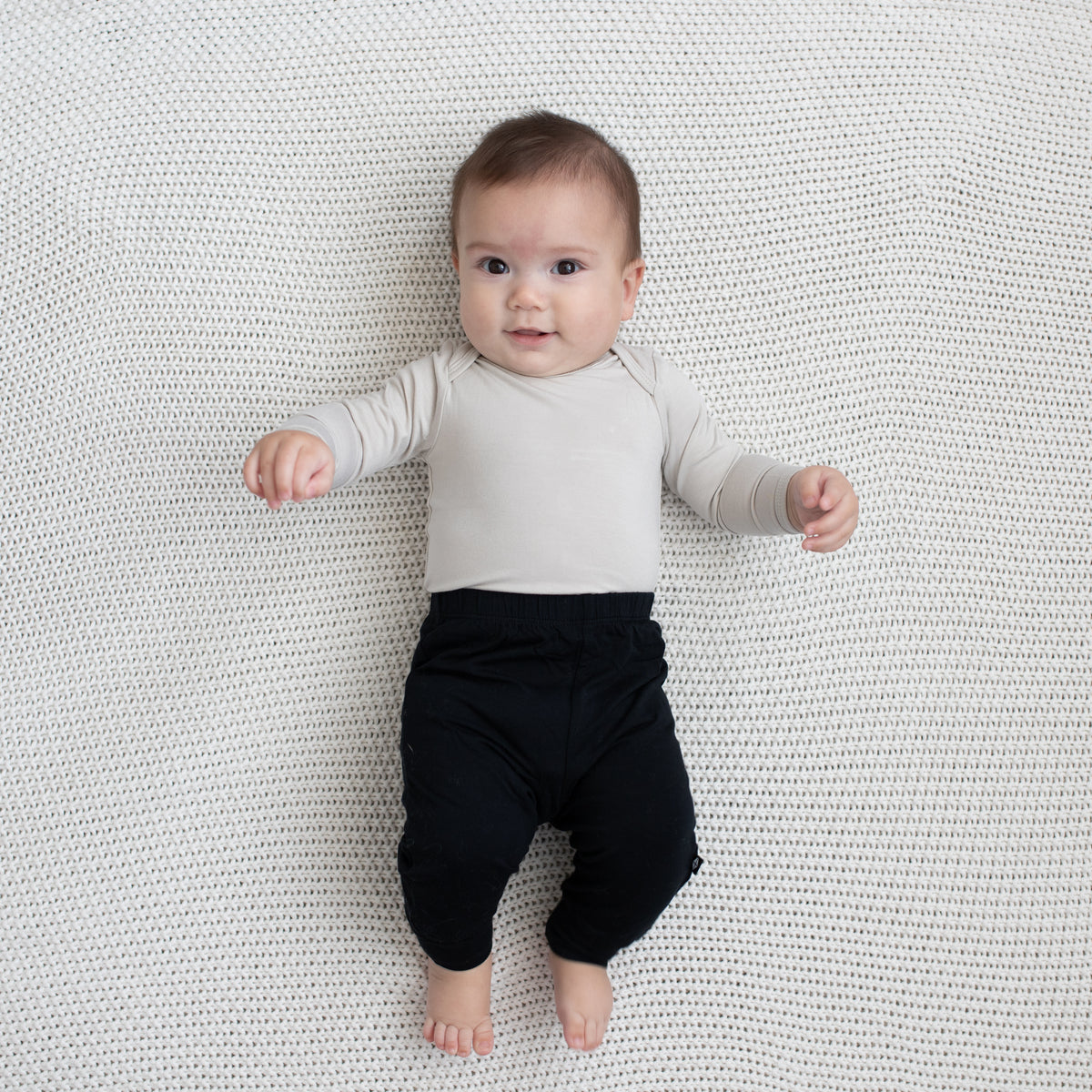 Baby modeling Pant in Midnight and Oat Long Sleeve Bodysuit