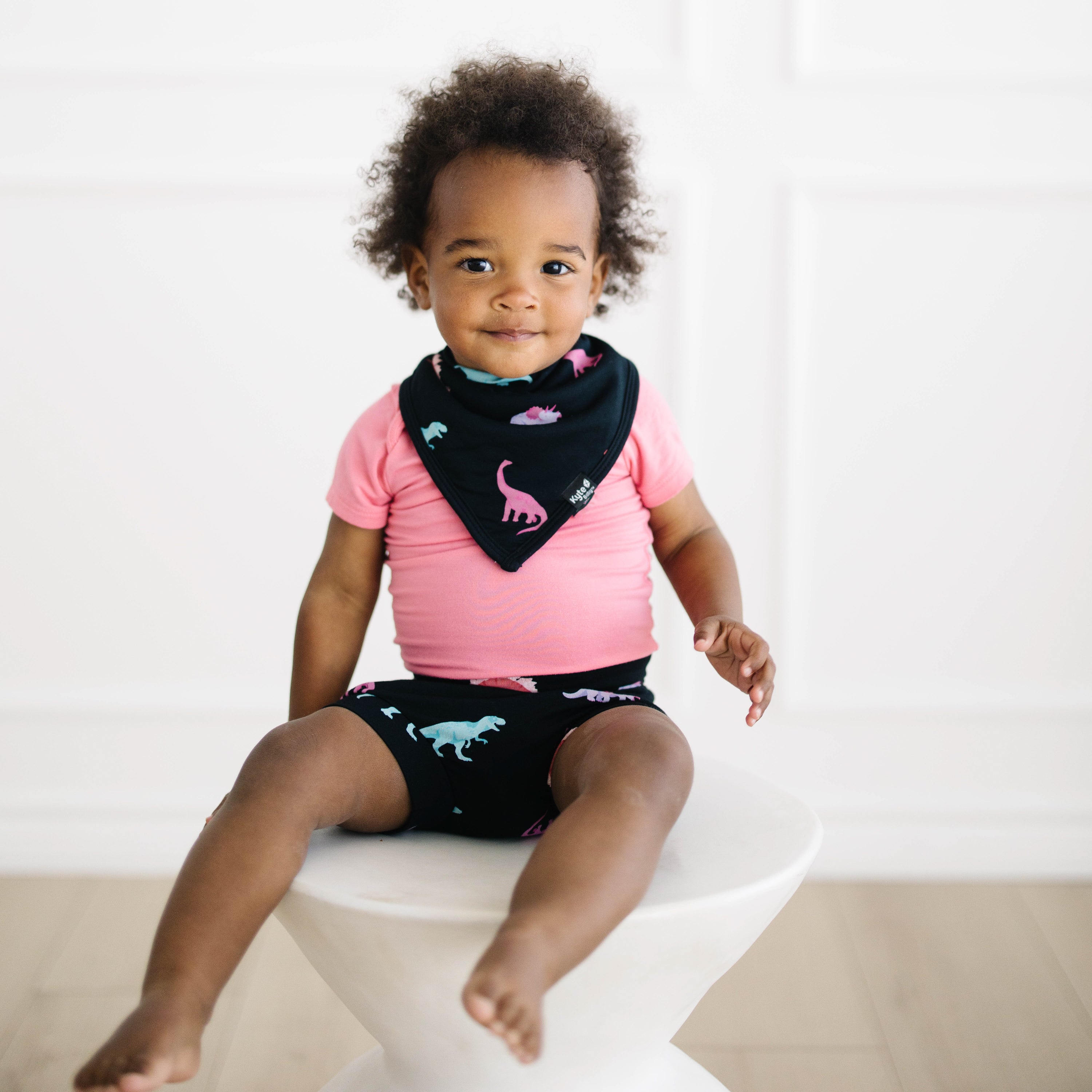 Toddler wearing Bib in Midnight Roar and Bummies with Guava bodysuit
