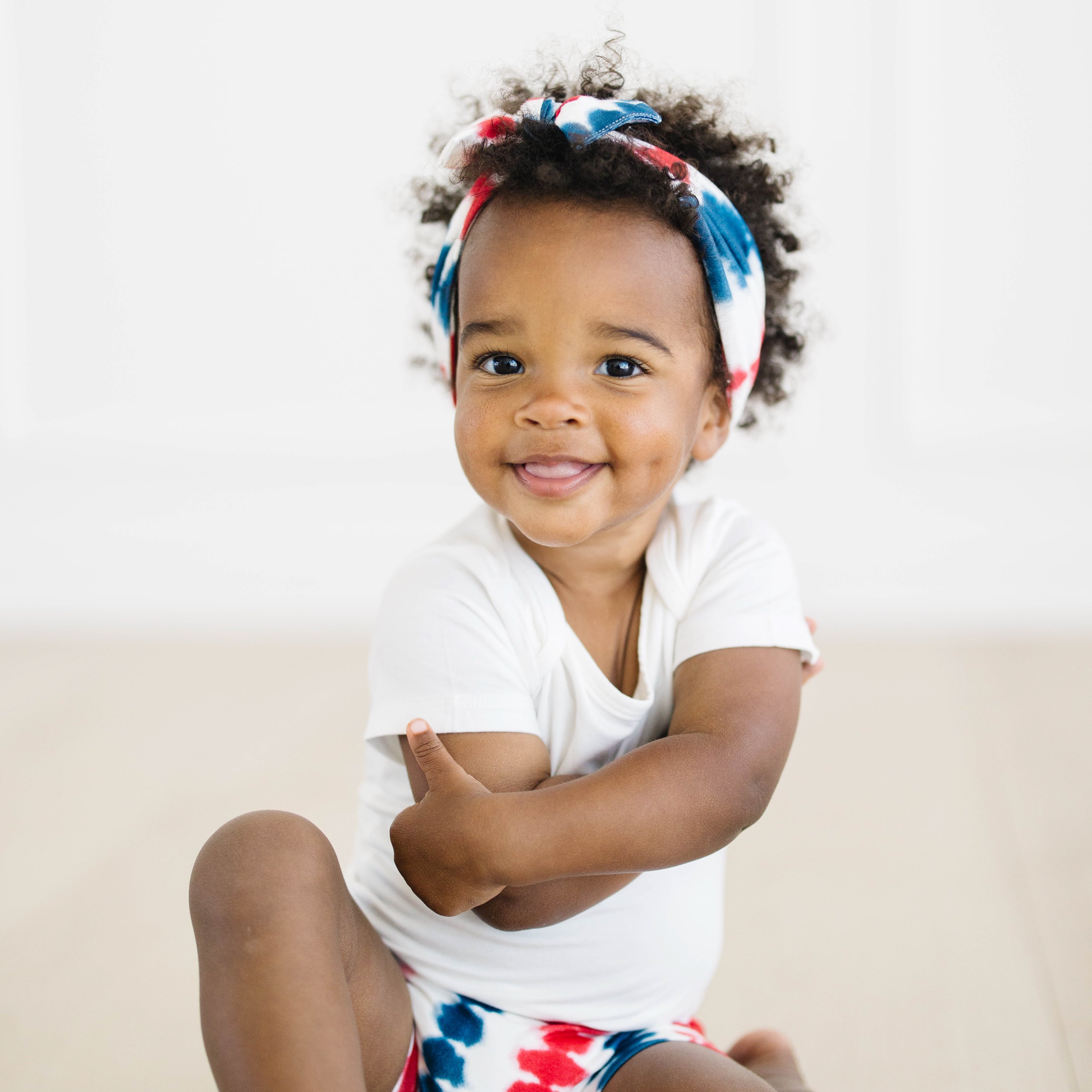 Baby smiling wearing Knotted Bow Headband in Liberty Rip Tide