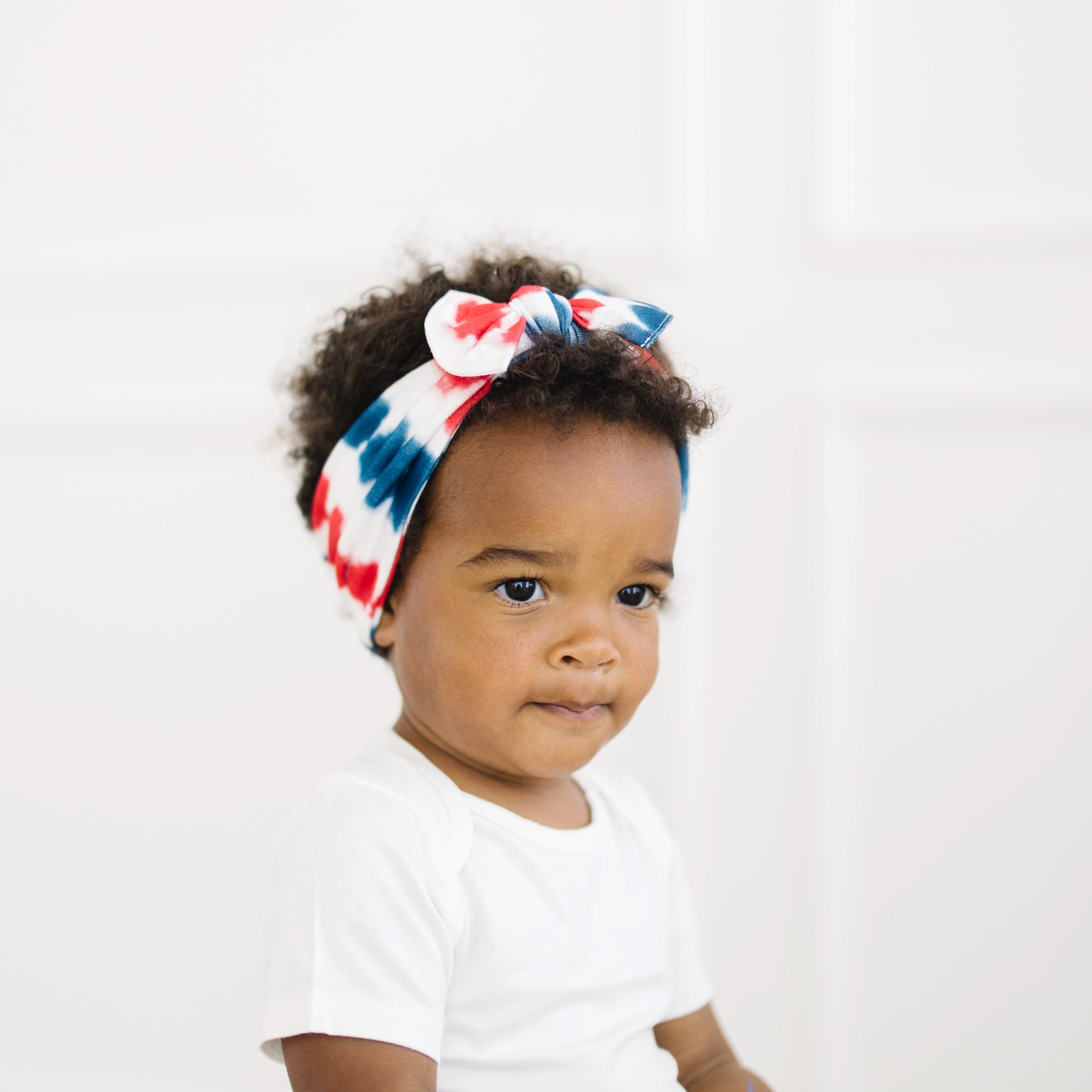 Baby wearing Knotted Bow Headband in Liberty Rip Tide