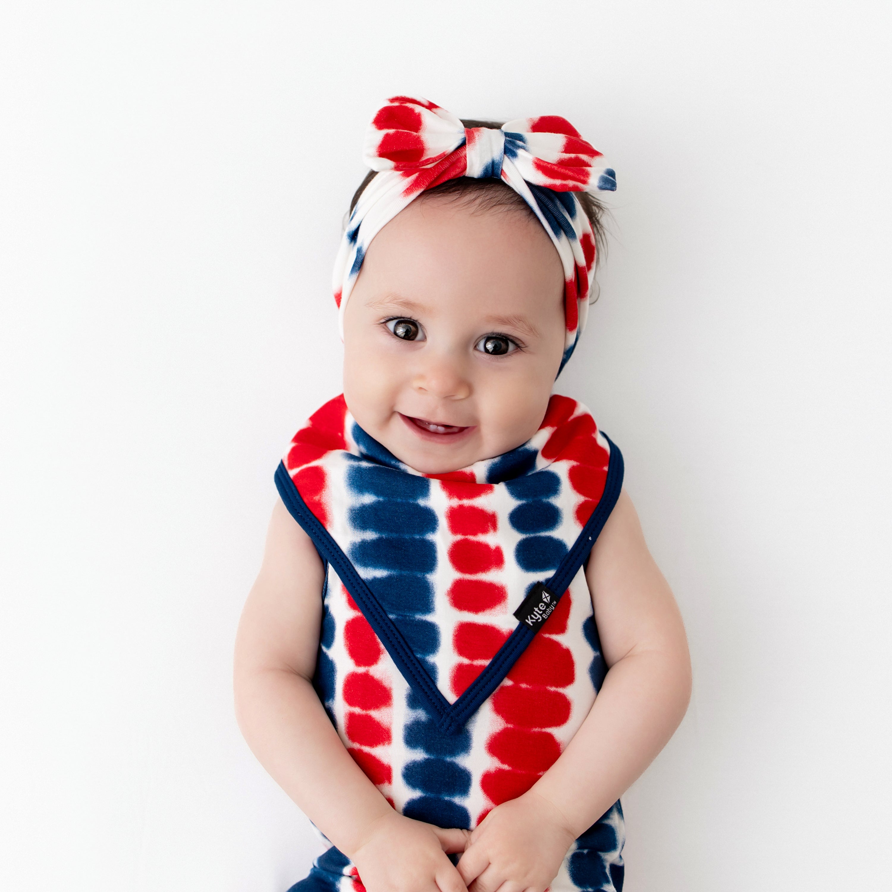 Baby wearing Bow Headband in Liberty Rip Tide and matching Bib and Bodysuit