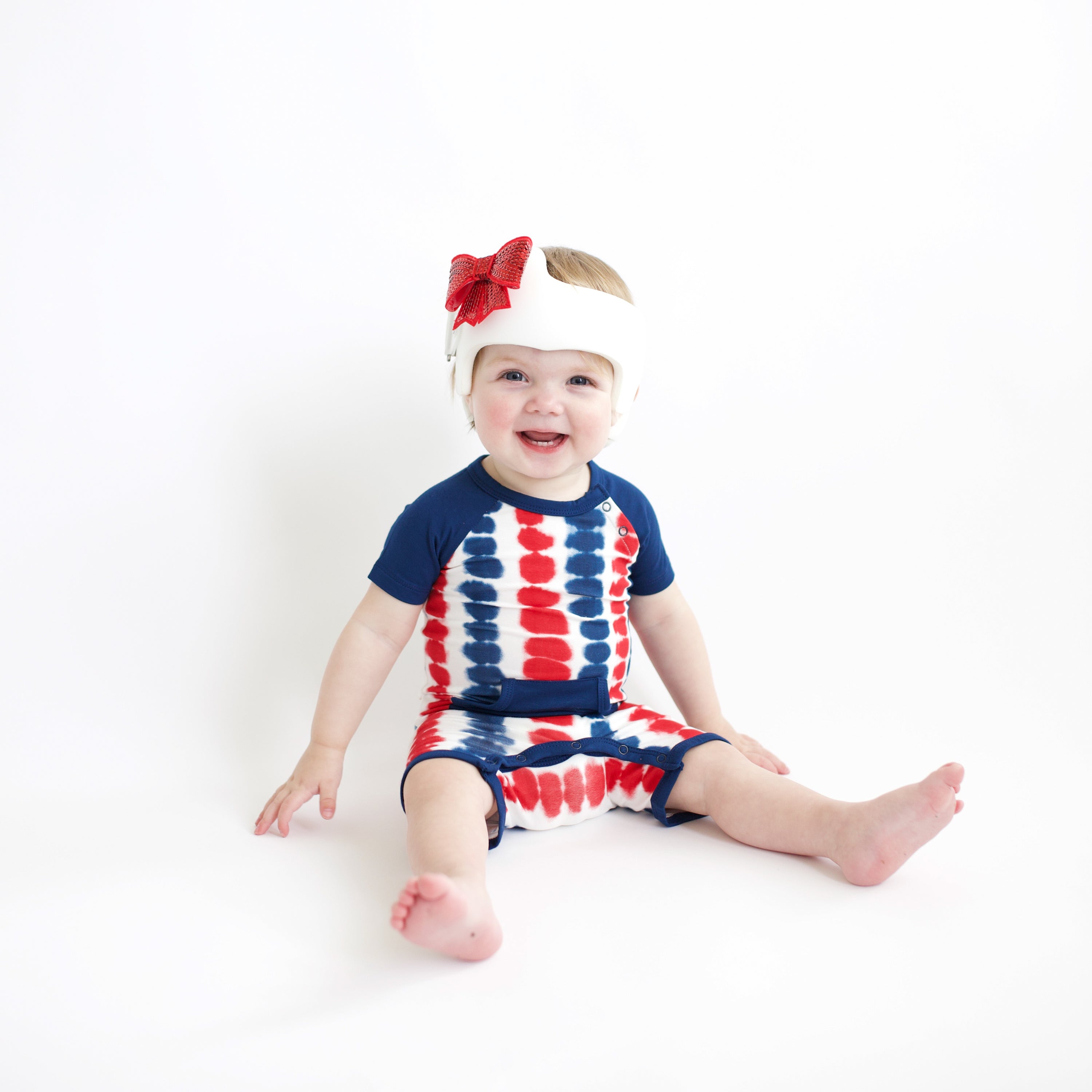 Baby sitting wearing Shortall in Liberty Rip Tide