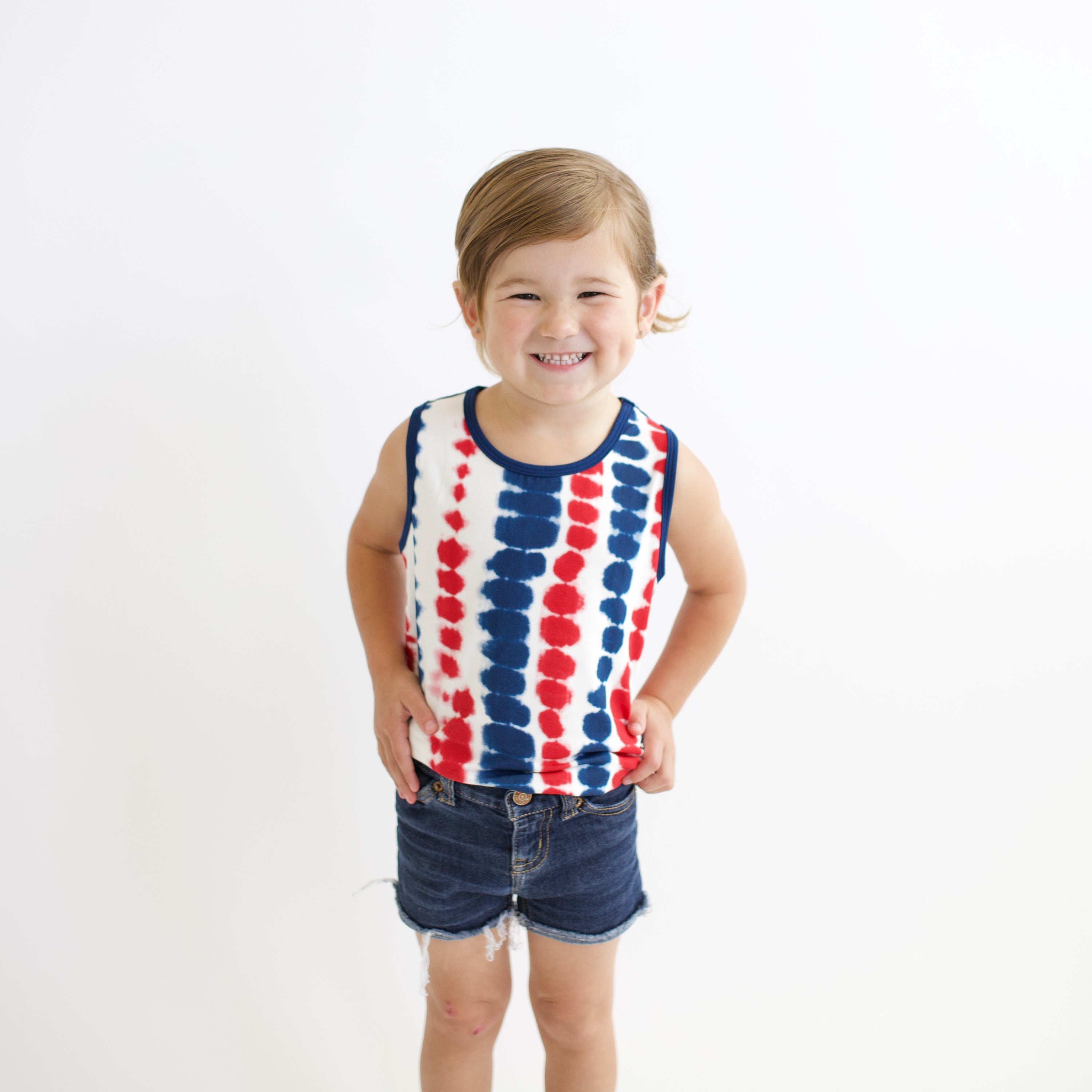 Toddler smiling modeling Toddler Tank Top in Liberty Rip Tide