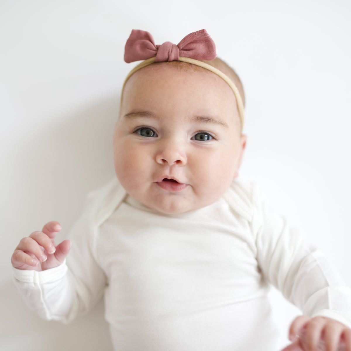Baby wearing Bamboo Muslin Tiny Bow in Dusty Rose Pink