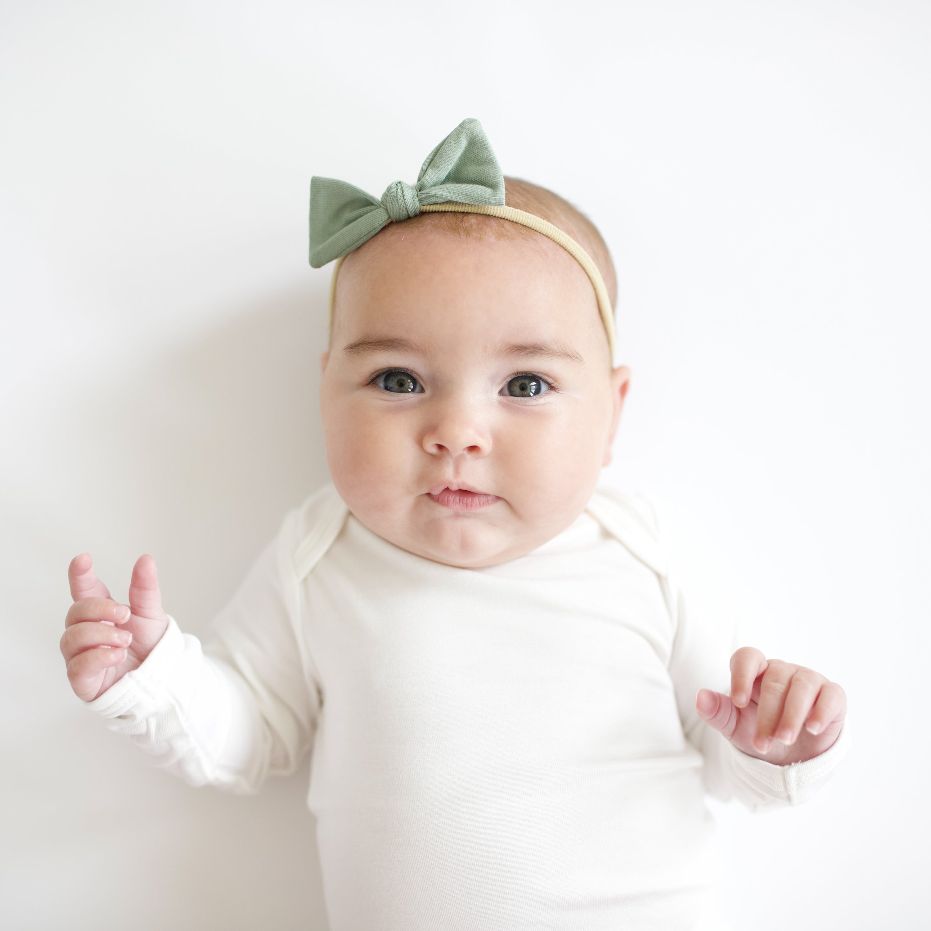 Close up of baby wearing Tiny Nylon Bow in Thyme