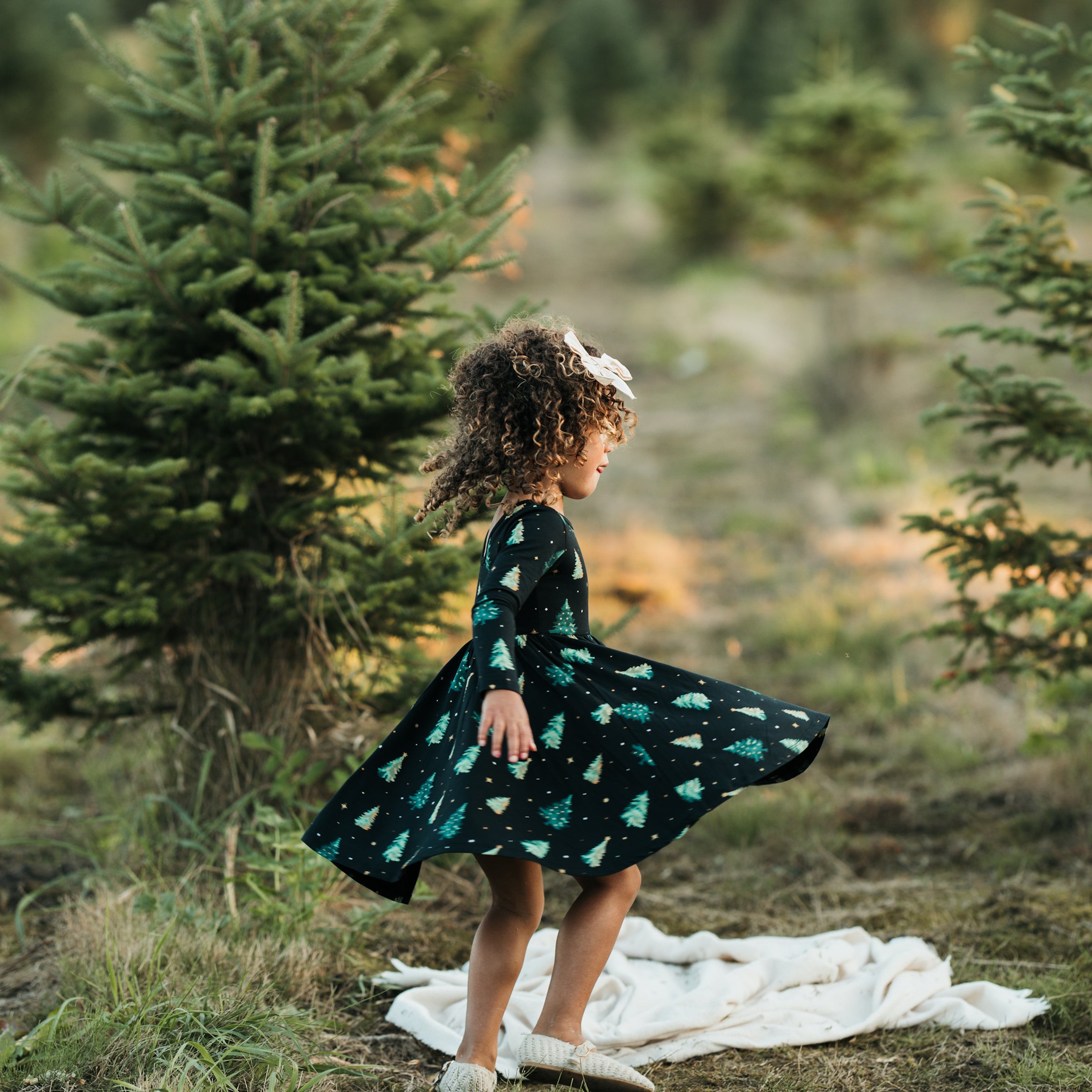 Young girl standing outside twirling in the Long Sleeve Twirl Dress in Twinkle Tree