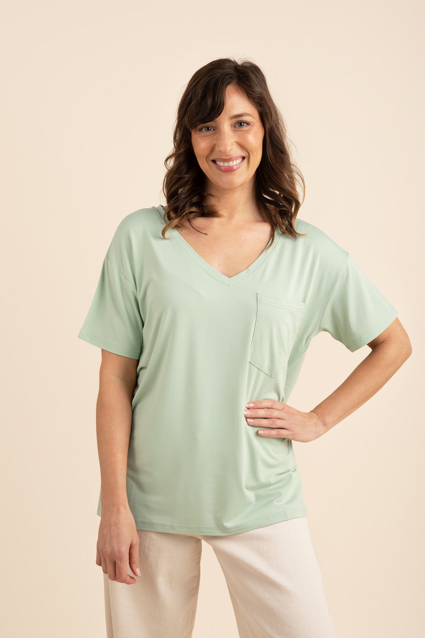 Woman wearing a light green bamboo v-neck and cream pants