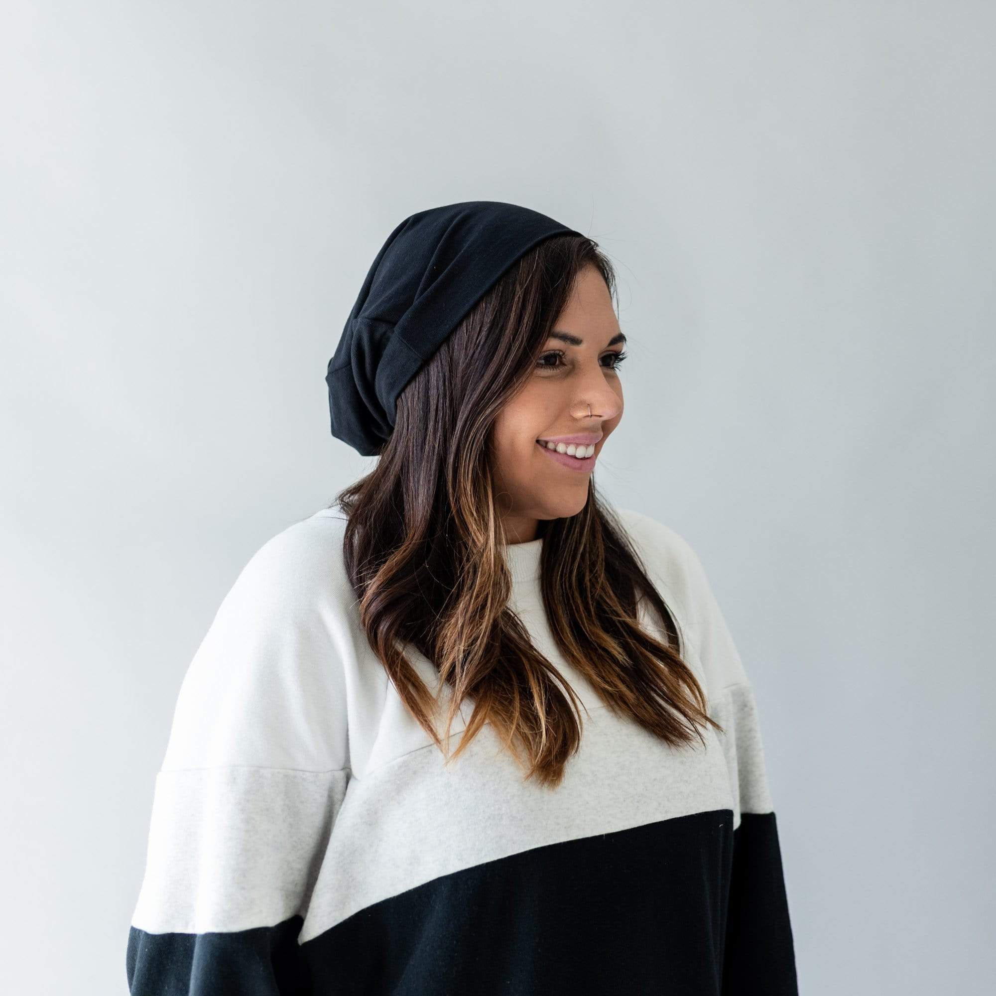 Woman wearing Kyte Baby bamboo slouchy Beanie in Midnight black