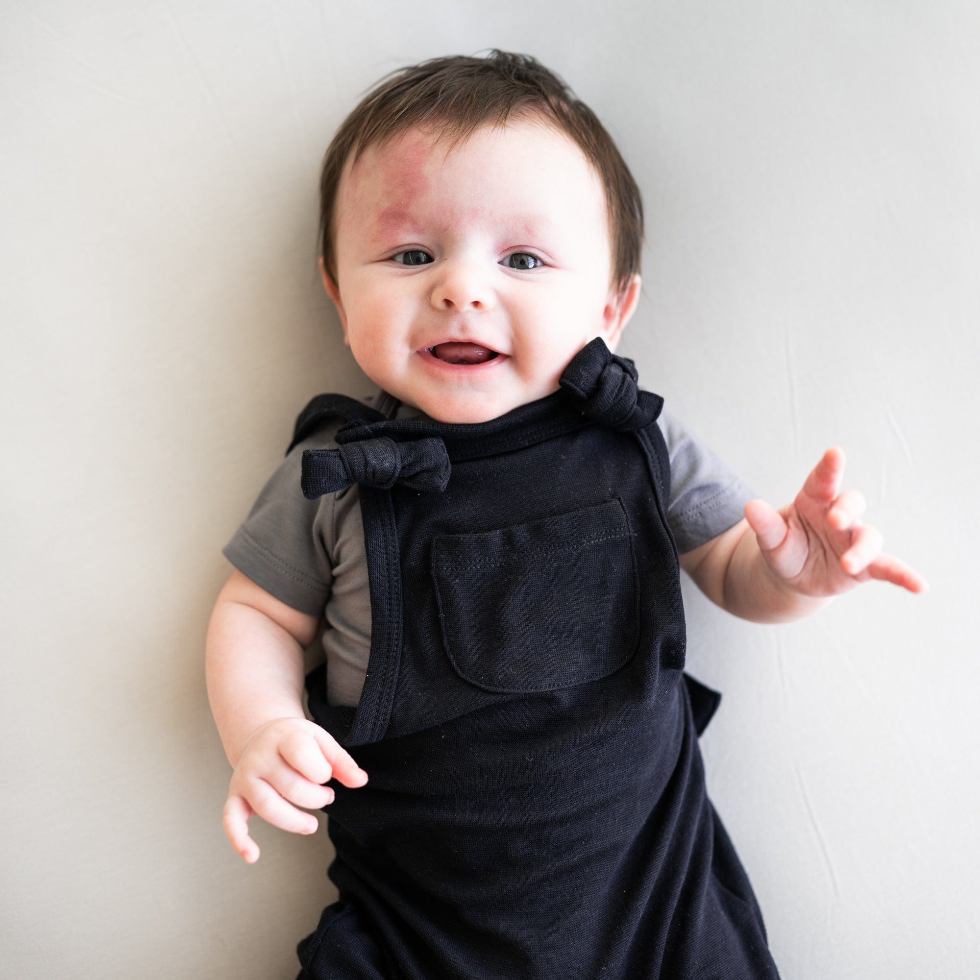 Infant wearing Kyte Baby Bamboo Jersey adjustable Overall in Midnight