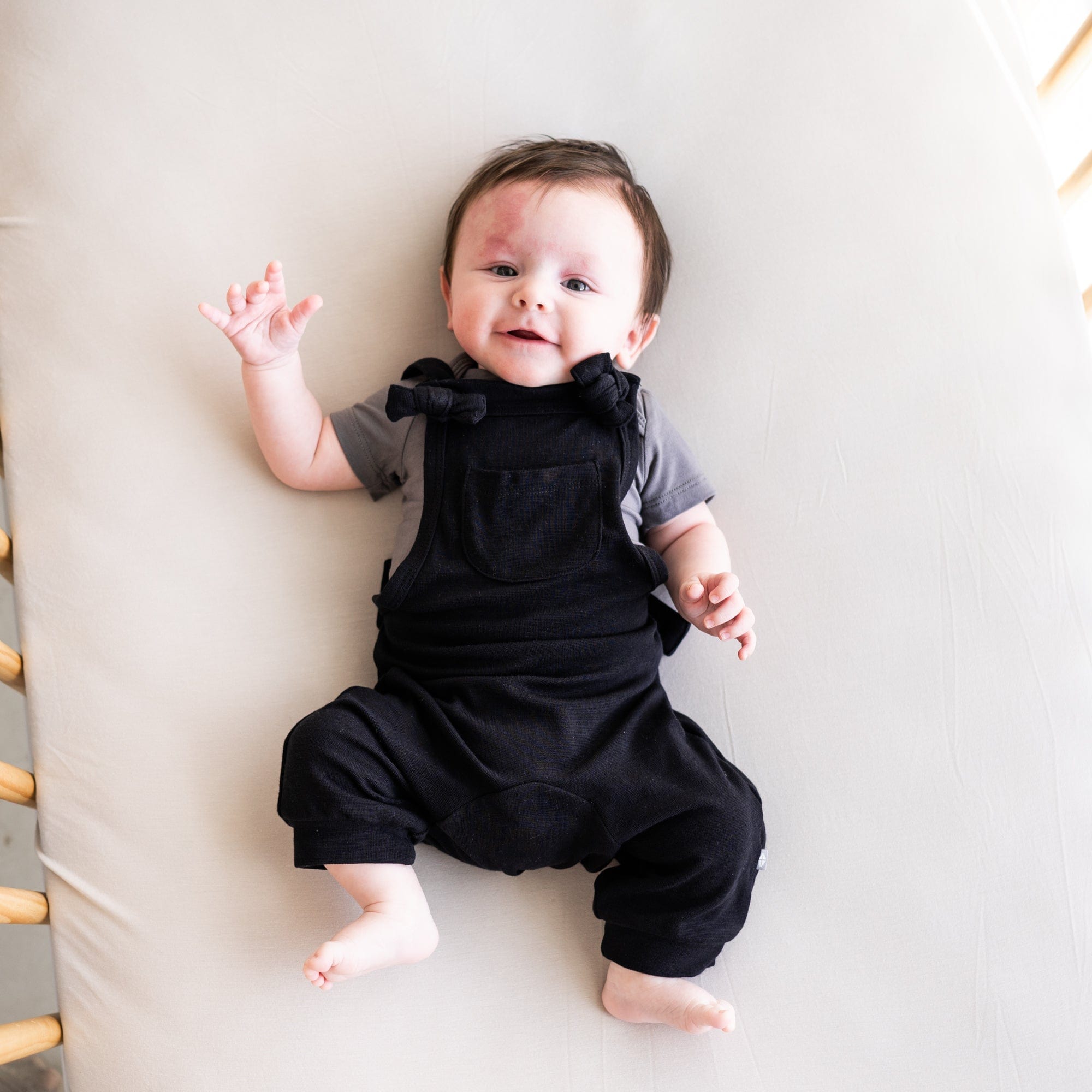Infant wearing Kyte Baby Bamboo Jersey Overall in Midnight
