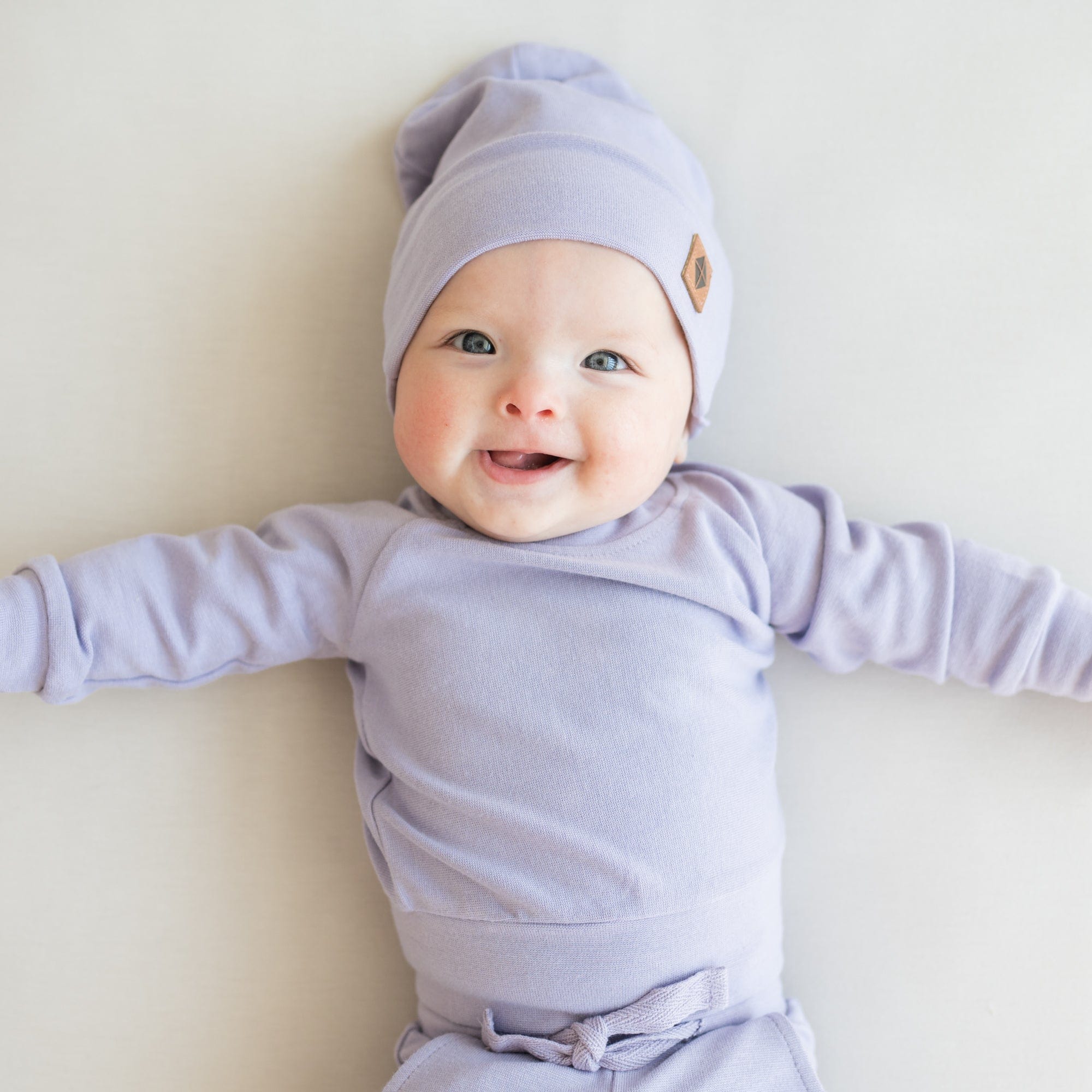 Infant wearing Kyte Baby Bamboo Jersey Beanie in Taro