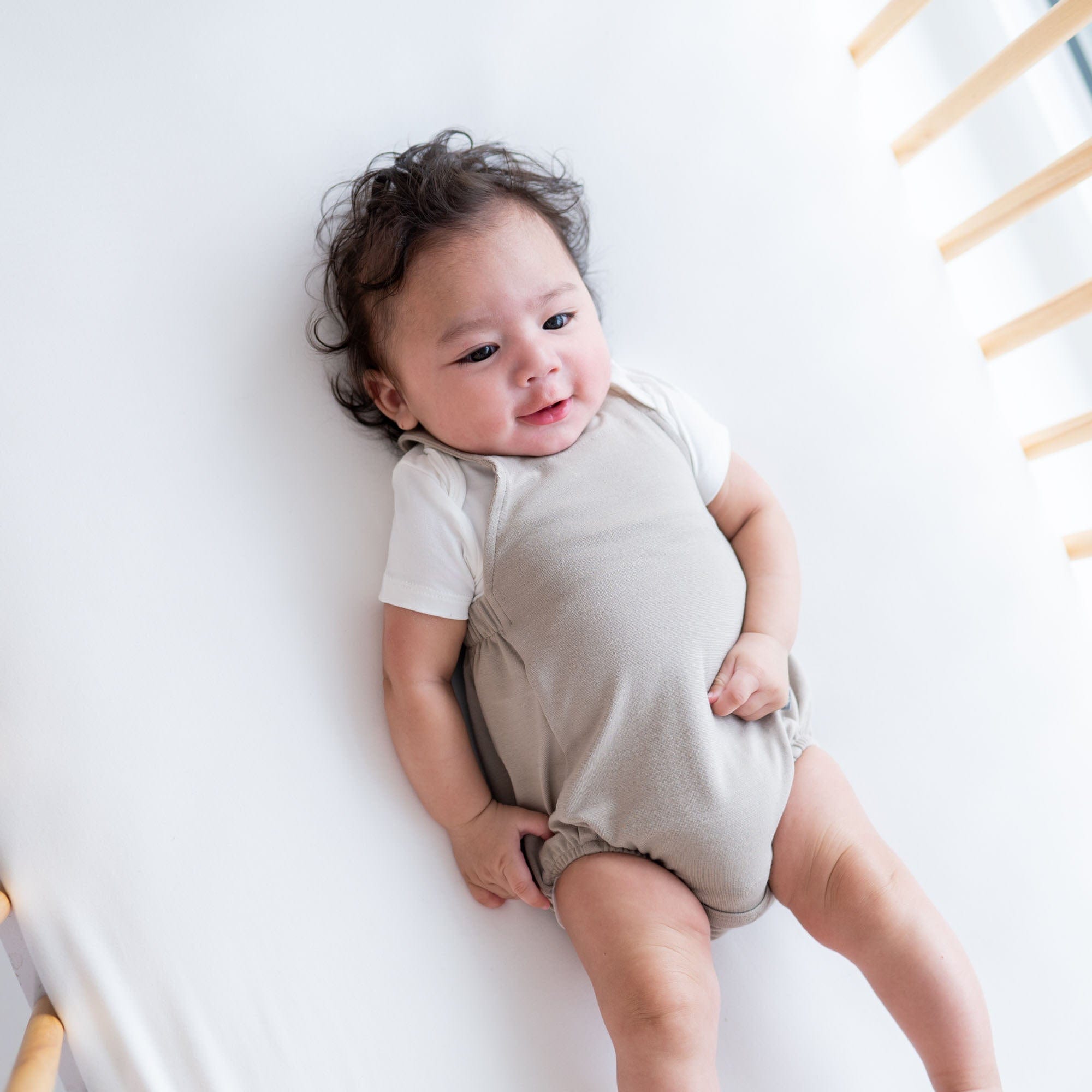 Baby wearing Kyte Baby Bamboo Jersey Bubble Overall in Khaki