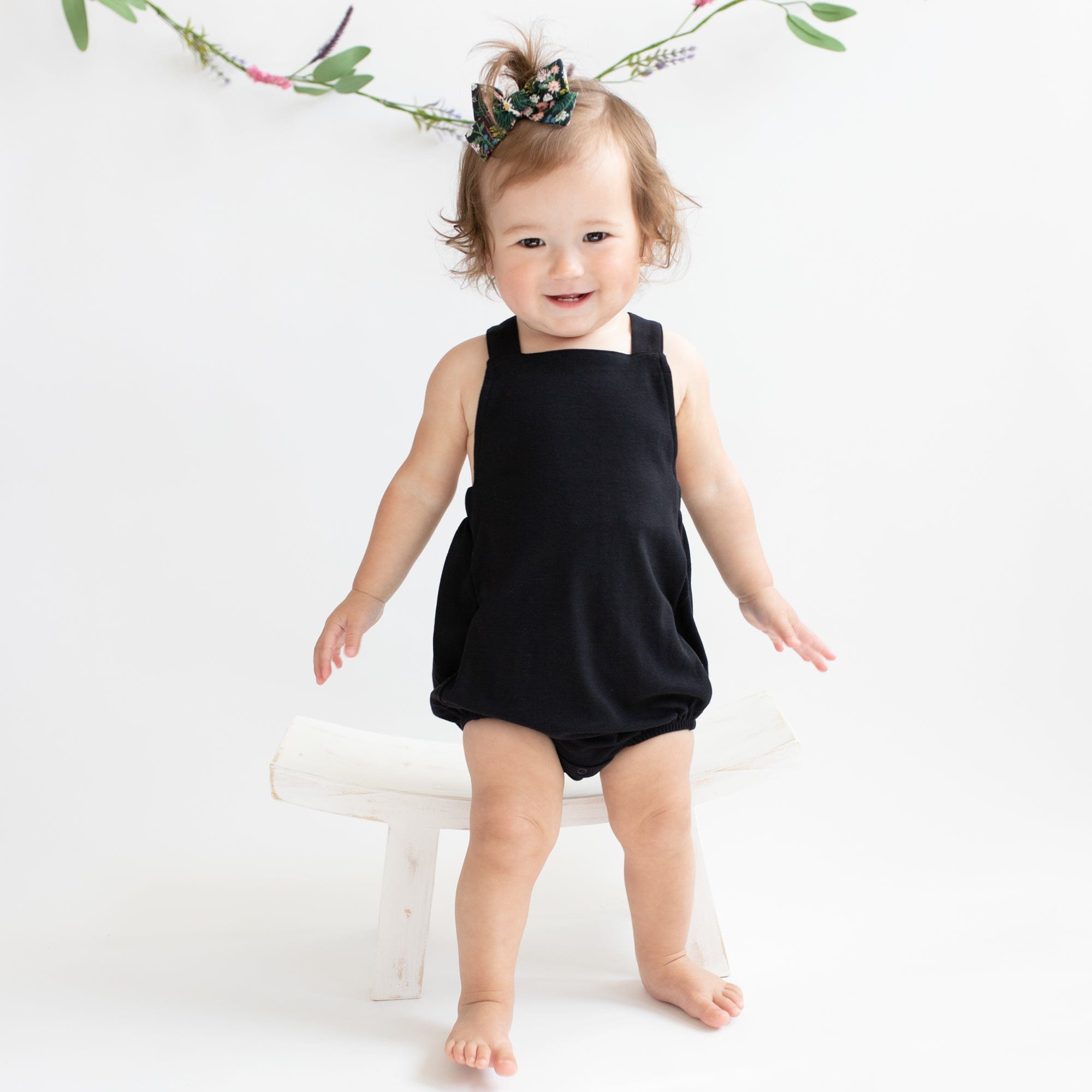 Toddler wearing Kyte Baby Bamboo Jersey Bubble Overall with Crossover Straps in Midnight black