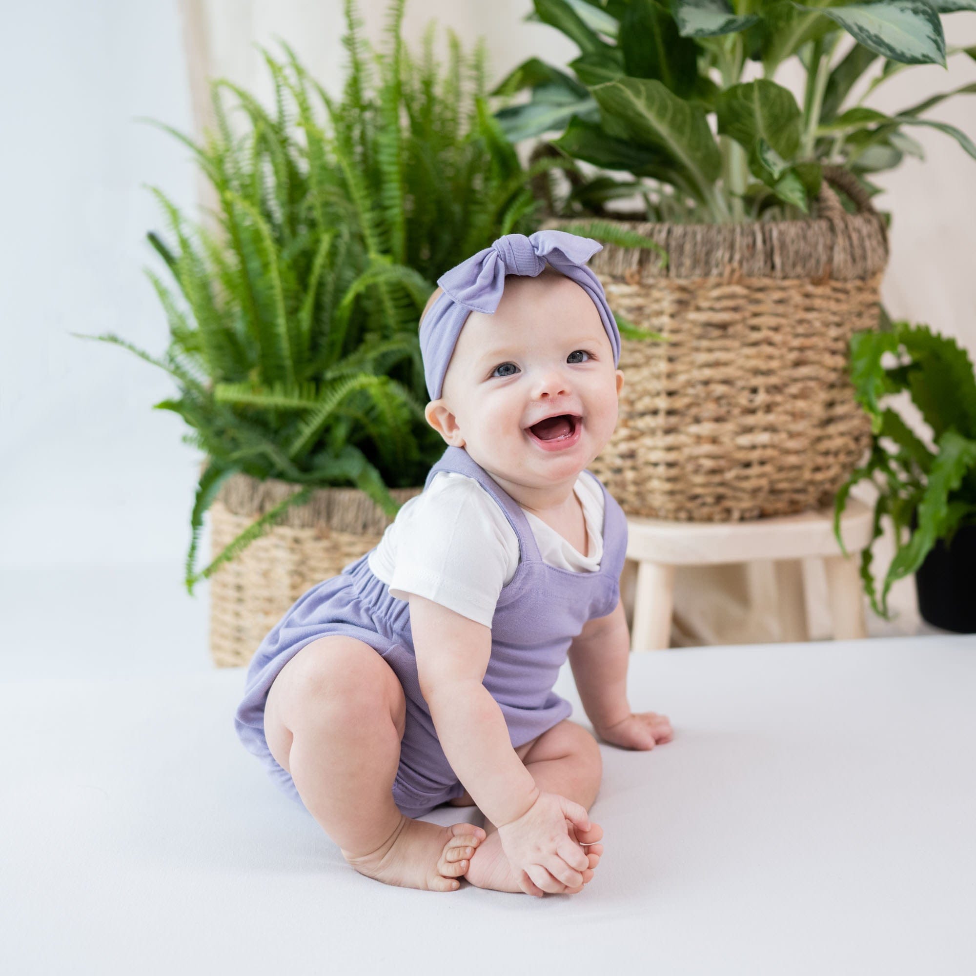 Infant wearing Kyte Baby Bamboo Jersey Bubble Overall in Taro