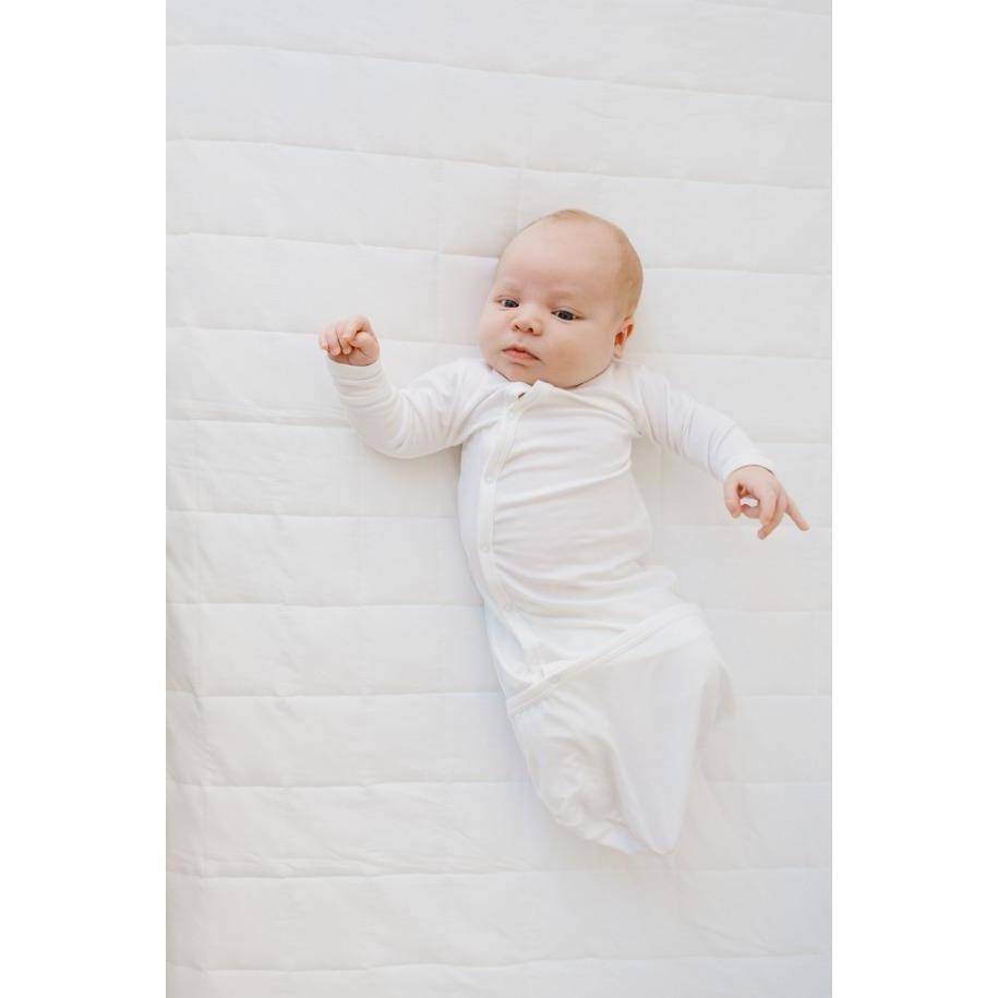 Infant wearing Kyte Baby Bundler in Cloud laying on a Cloud blanket, stitching side up