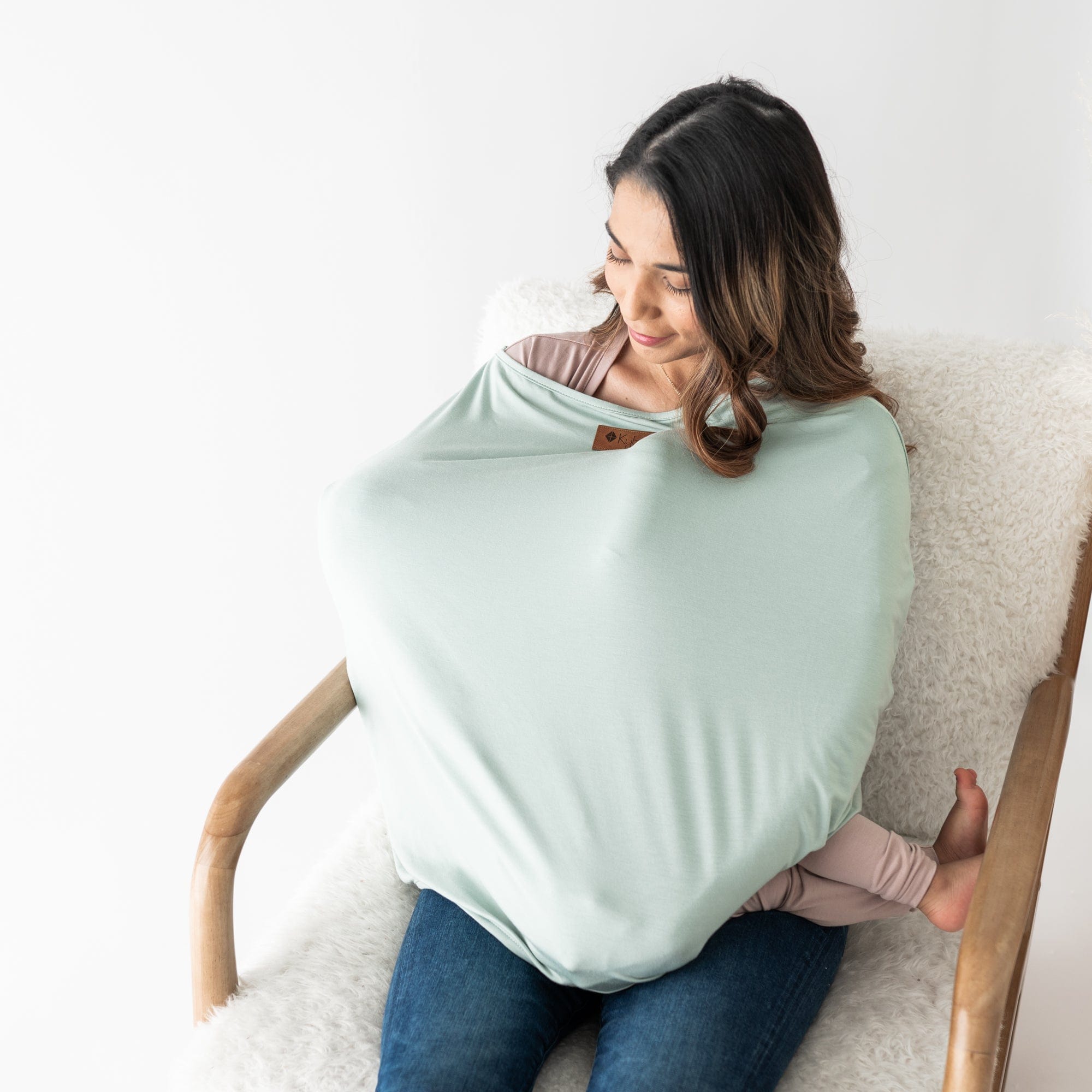 Mom nursing baby using Kyte Baby 3-in-1 bamboo Cover in Sage