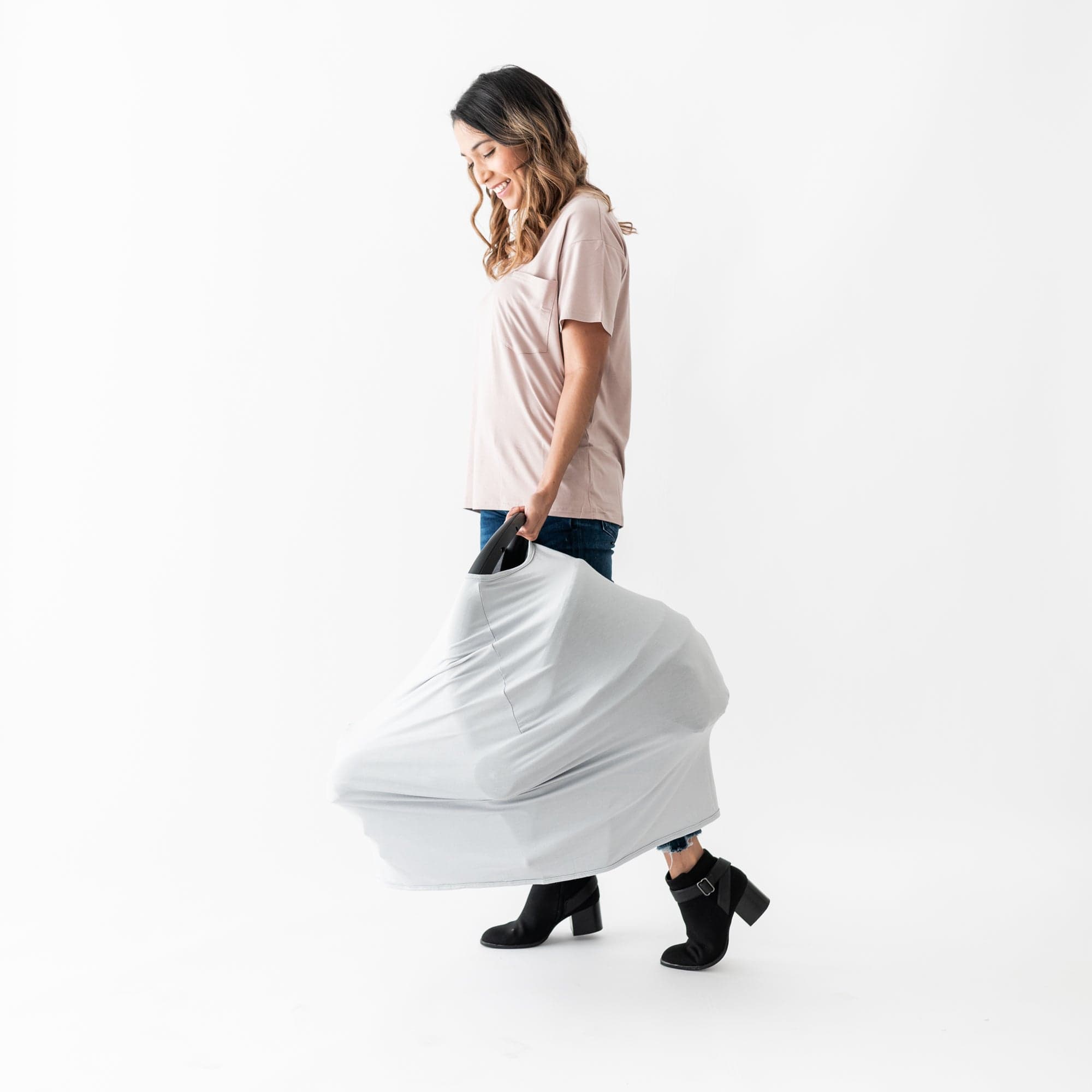 Mom carrying baby car seat with Kyte Baby carseat and nursing cover in Storm