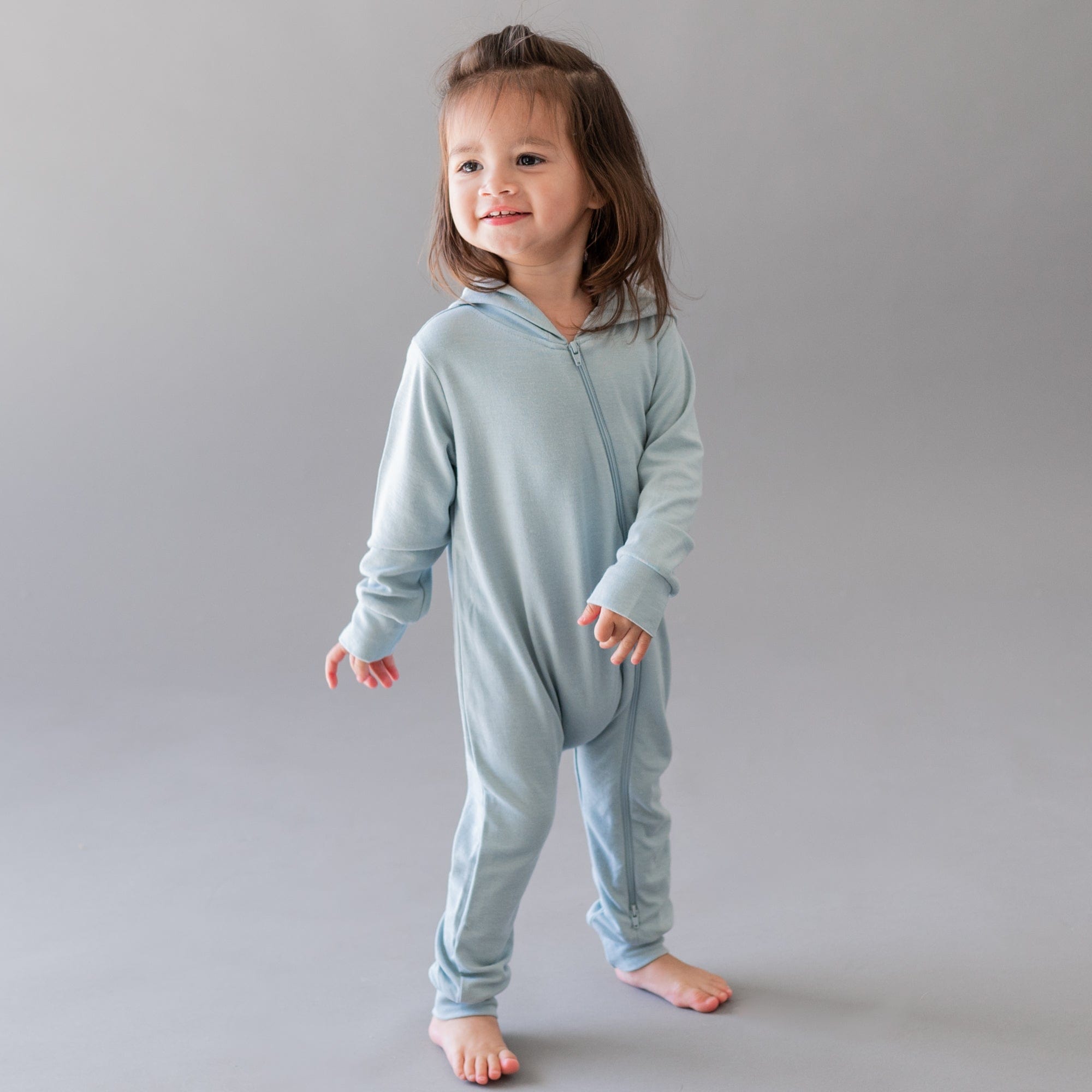 Toddler wearing Kyte Baby Bamboo Jersey Hooded Zippered Romper in Fog