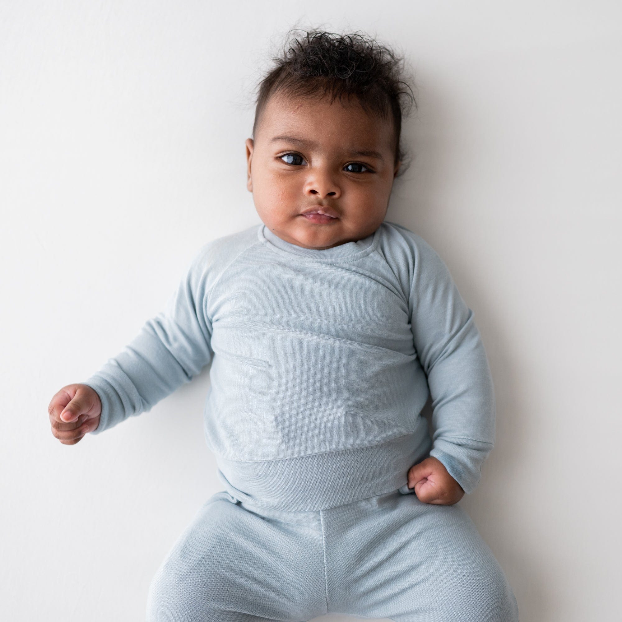 Infant wearing Kyte Baby Bamboo Jersey Long Sleeve Jogger Set in Fog
