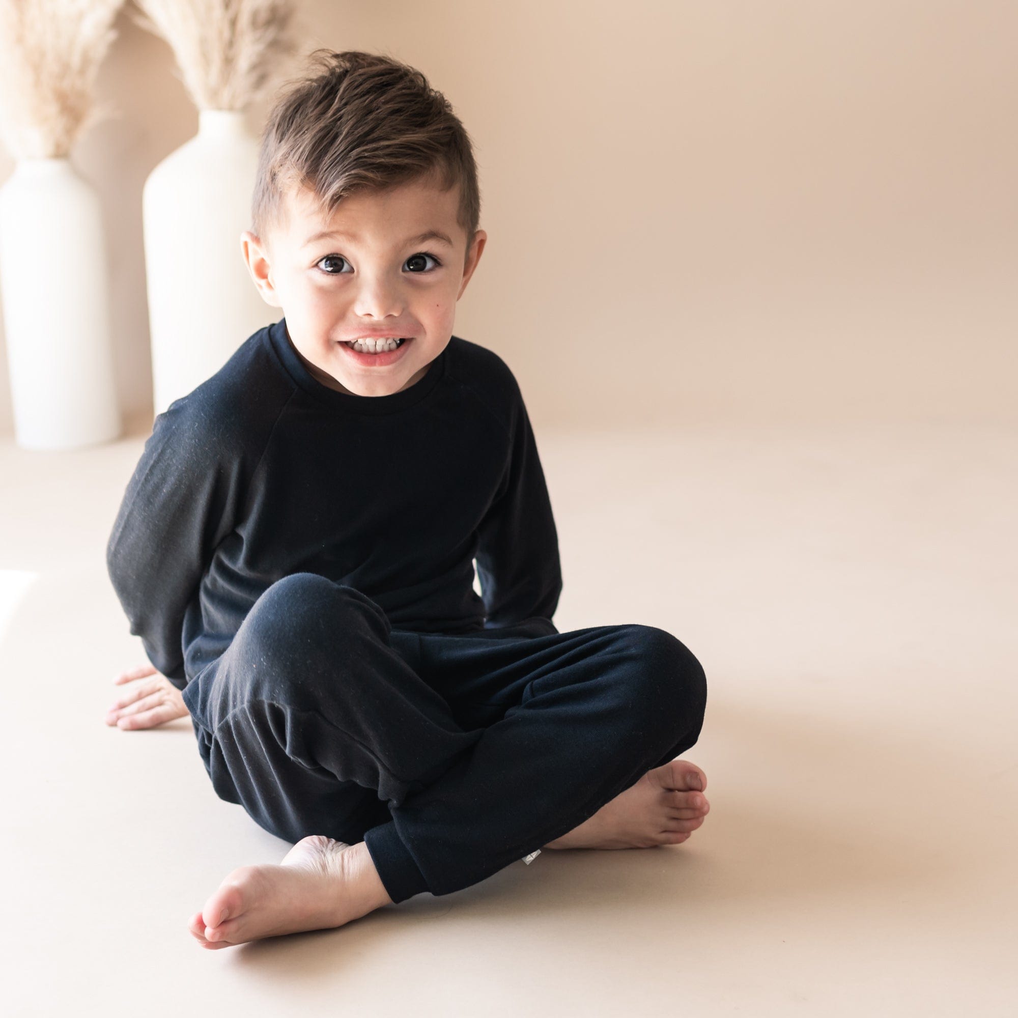 Boy wearing Kyte Baby Bamboo Jersey Jogger Set with drawstring waist in Midnight