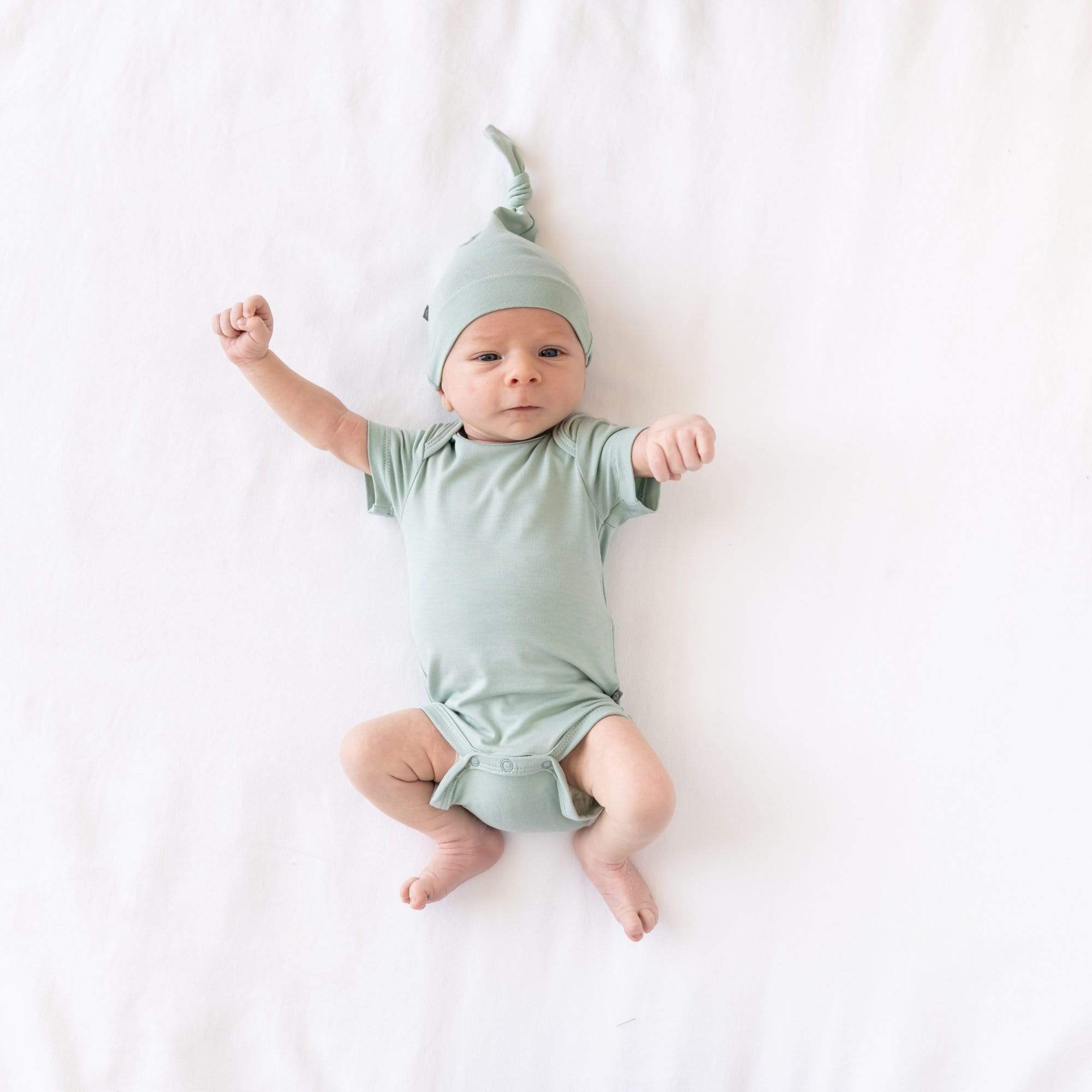 Newborn wearing Knotted Cap in Sage and matching short sleeve bodysuit