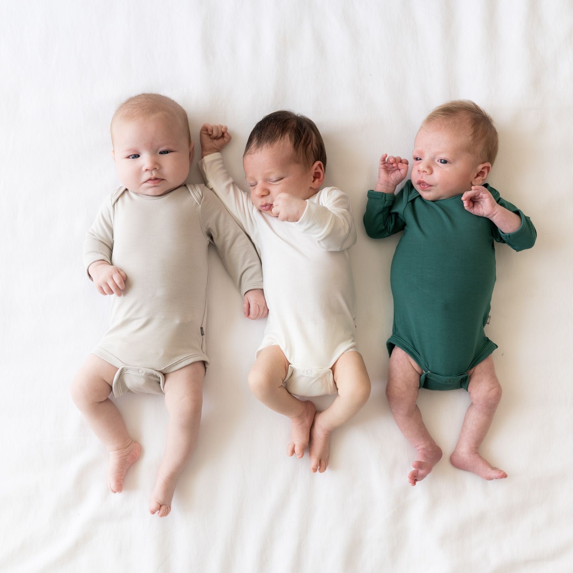 Newborns wearing Kyte Baby Long Sleeve Bodysuit onesies