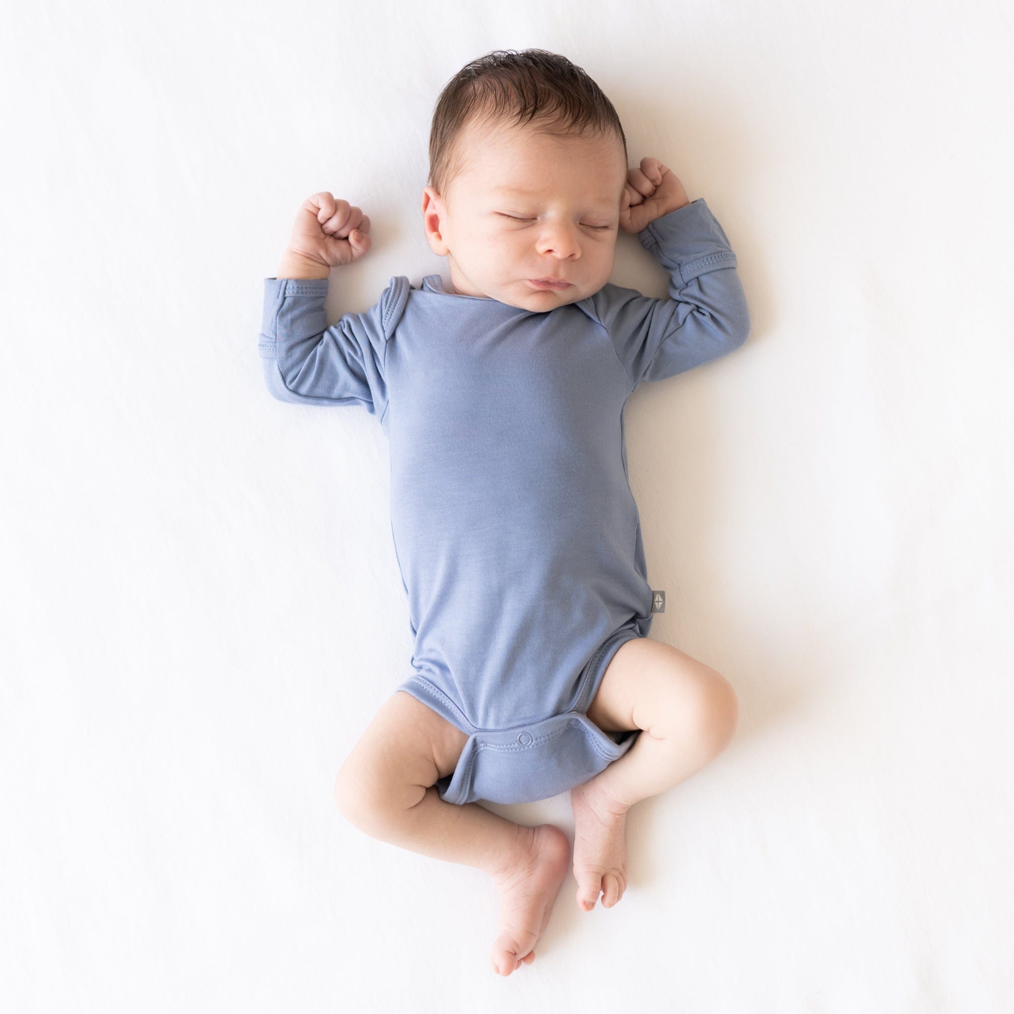 Baby wearing Kyte Baby Long Sleeve infant Bodysuit in Slate