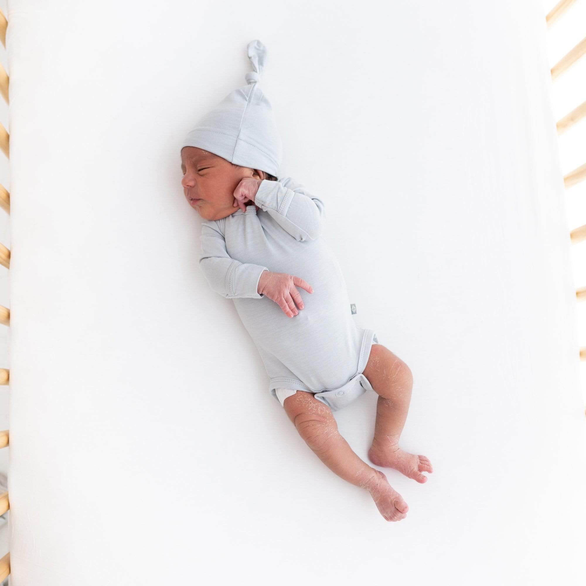 Newborn wearing Kyte Baby Long Sleeve Bodysuit in Storm