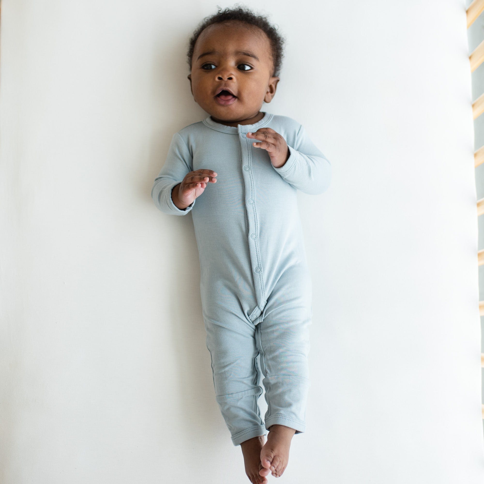 Infant wearing Kyte Baby Romper in Fog