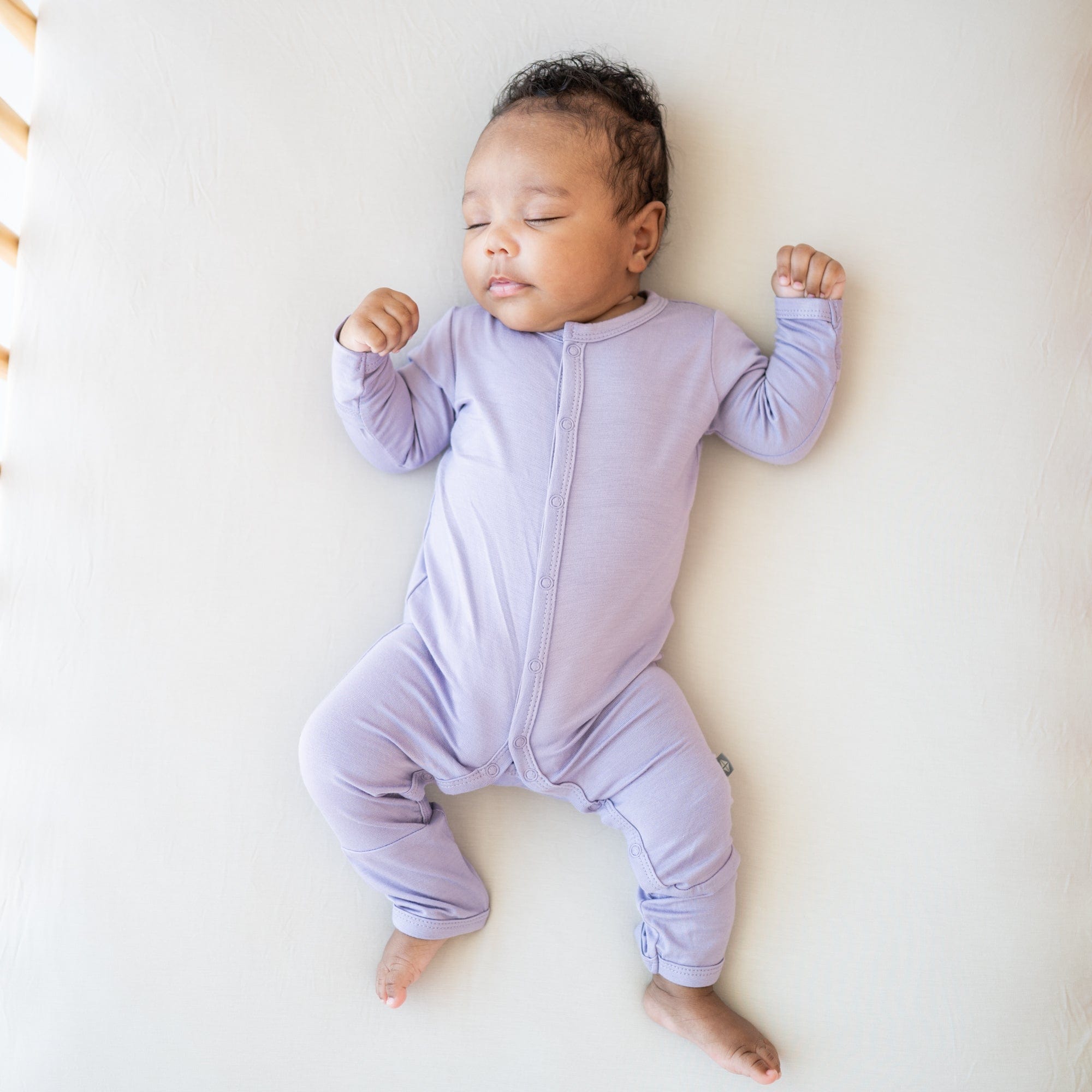 Infant wearing Kyte Baby Romper in Taro