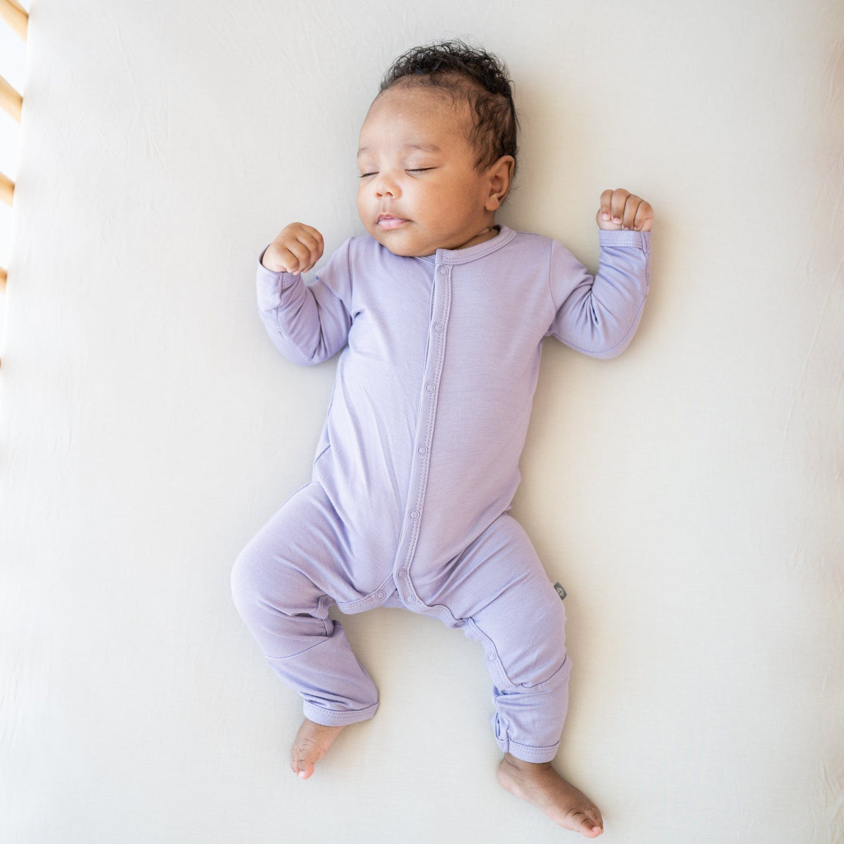 Infant wearing Kyte Baby Romper in Taro