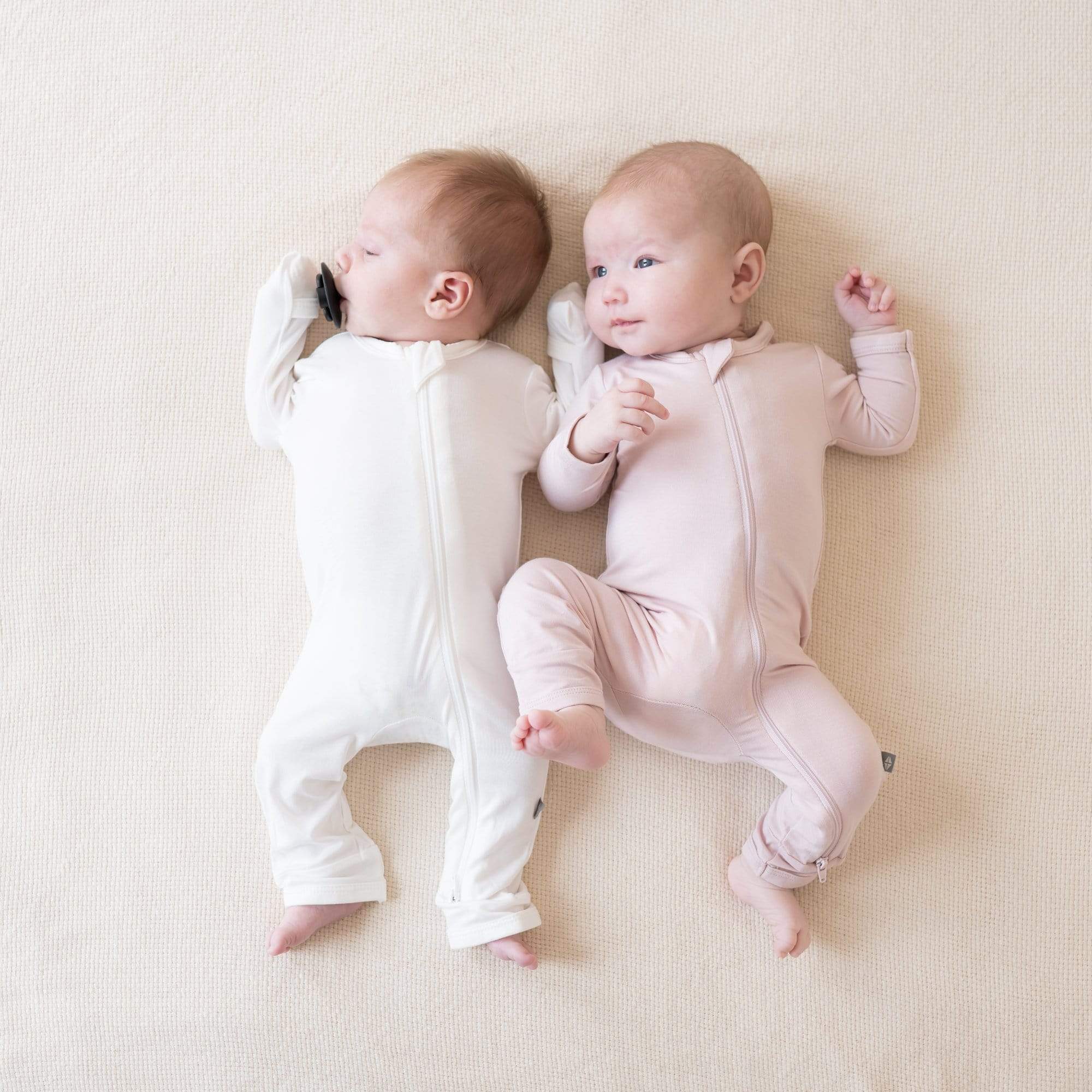 Babies wearing Kyte Baby bamboo Zippered Romper pajamas