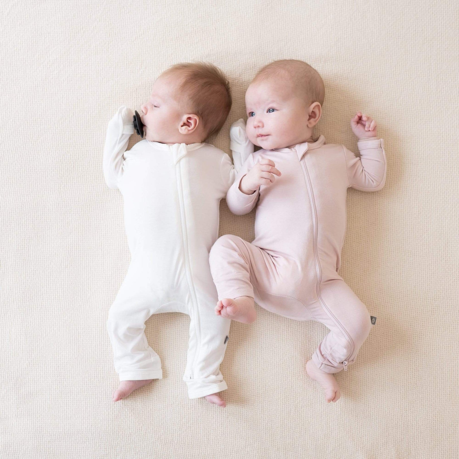 Babies wearing Kyte Baby bamboo Zippered Romper pajamas