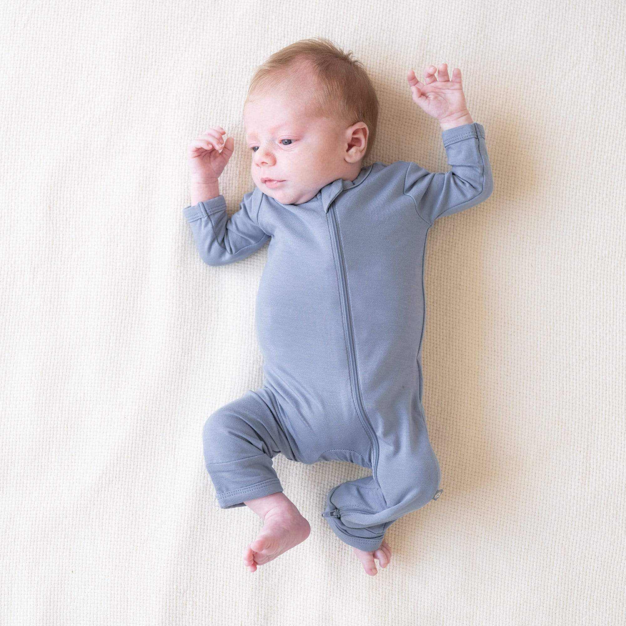Infant wearing Kyte Baby Zippered Romper in Slate