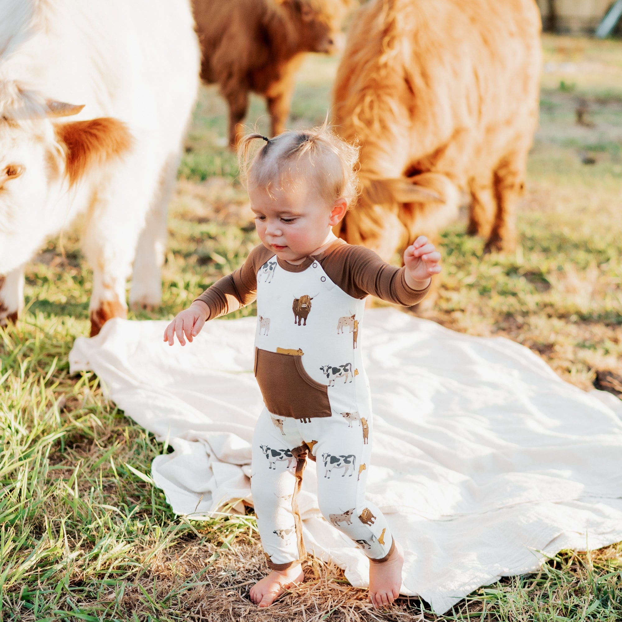 Toddler wearing Kyte Baby raglan style Longall with pocket in Moo