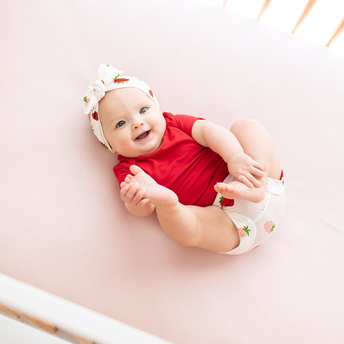 Infant wearing short sleeve Kyte Baby Bodysuit in Cardinal