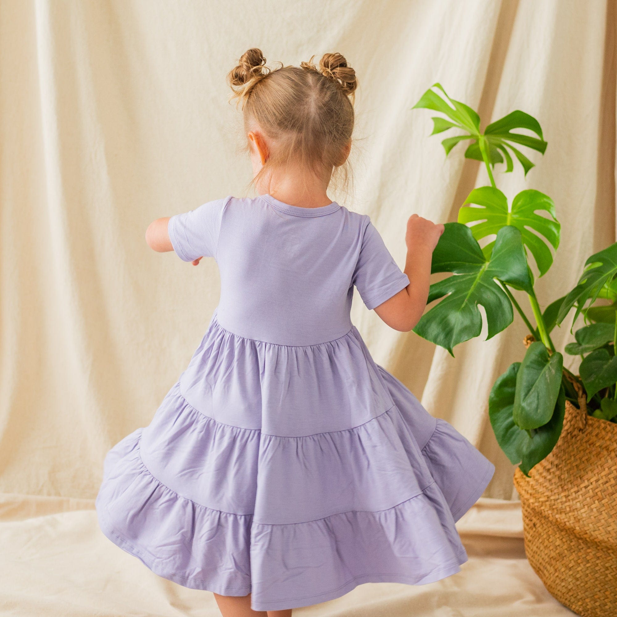 Twirling child wearing a a Short Sleeve Tiered Dress in Taro
