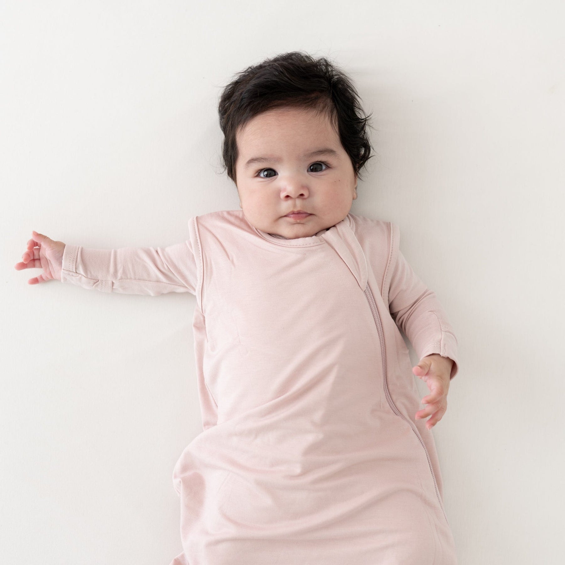 Baby wearing Kyte Baby bamboo Sleep Bag 0.5 in Blush