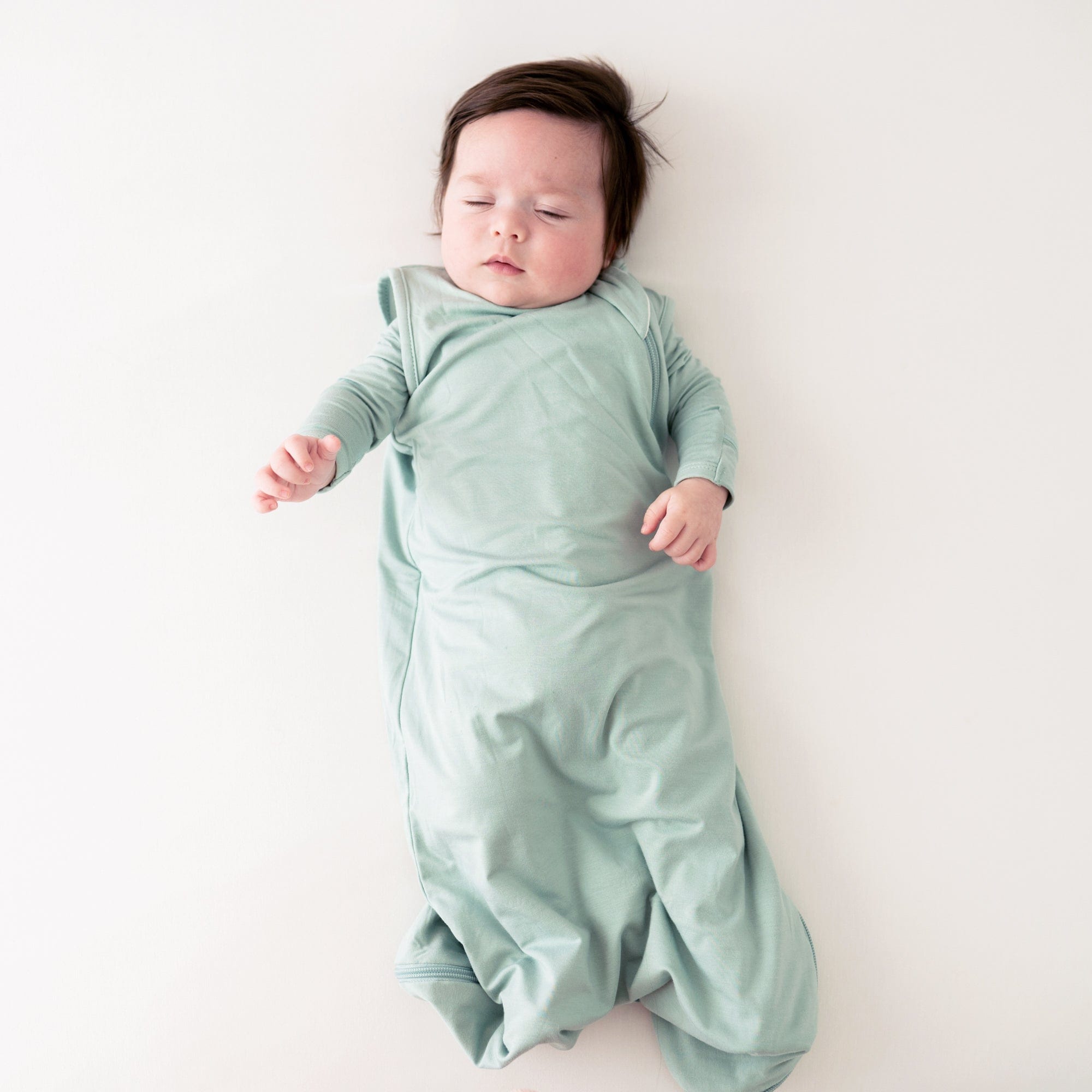 Baby wearing Kyte Baby bamboo Sleep Bag in Sage 0.5