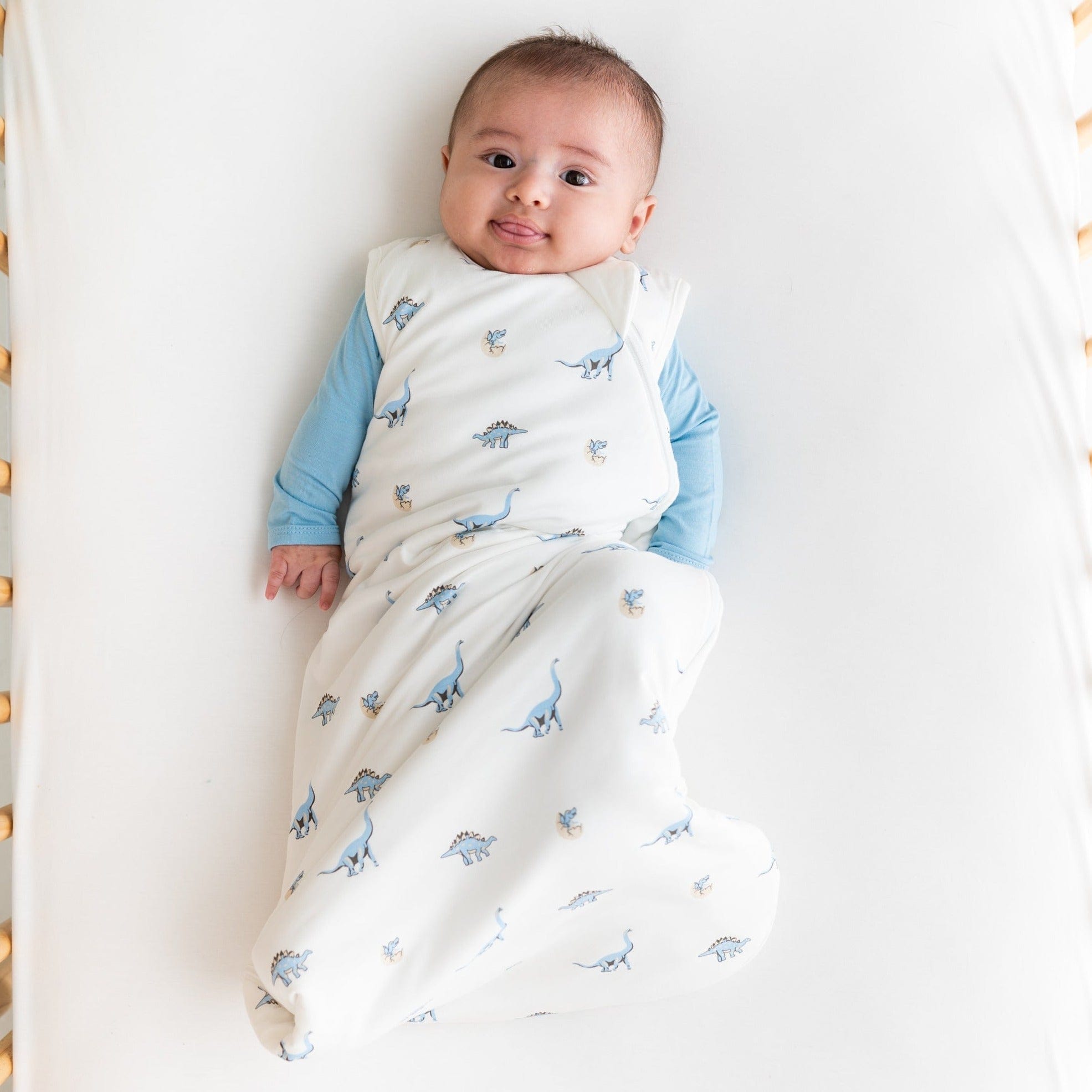 Baby sticking out tongue wearing Kyte Baby bamboo Sleep Bag in Jurassic 1.0 TOG