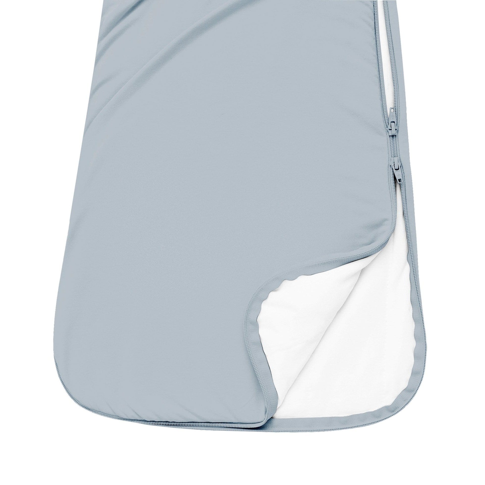 Close up of unzipped double zipper on Kyte Baby Sleep Bag in Fog 1.0