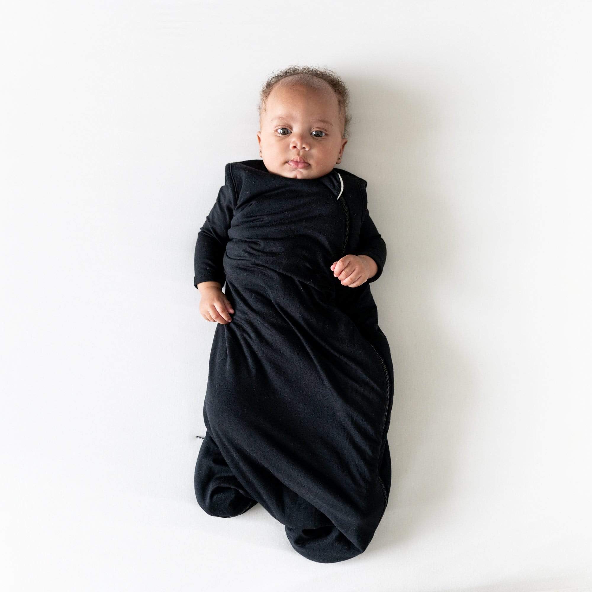 Baby wearing Kyte Baby Sleep Bag in Midnight 1.0