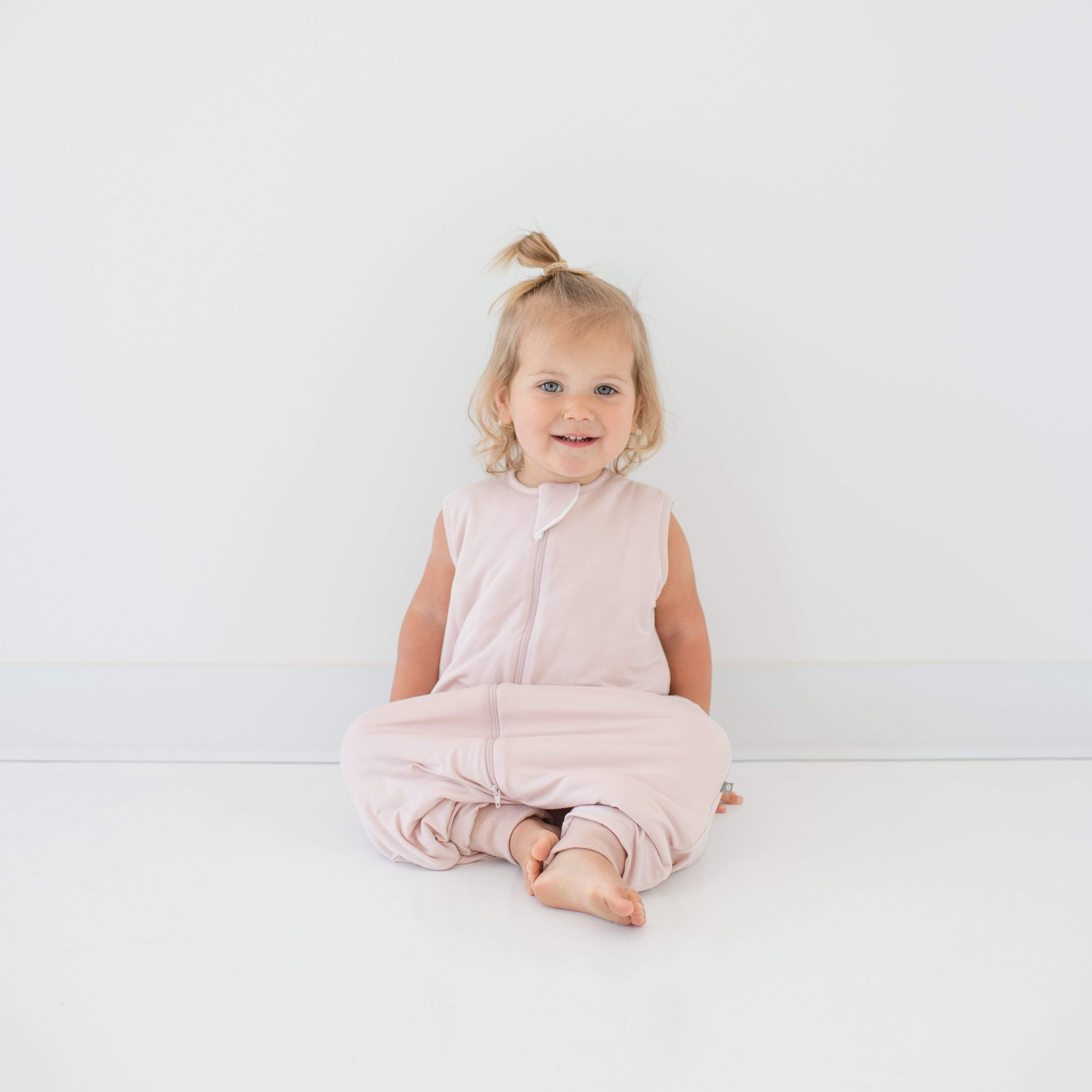 Toddler wearing Kyte Baby Sleep Bag Walker in Blush 2.5